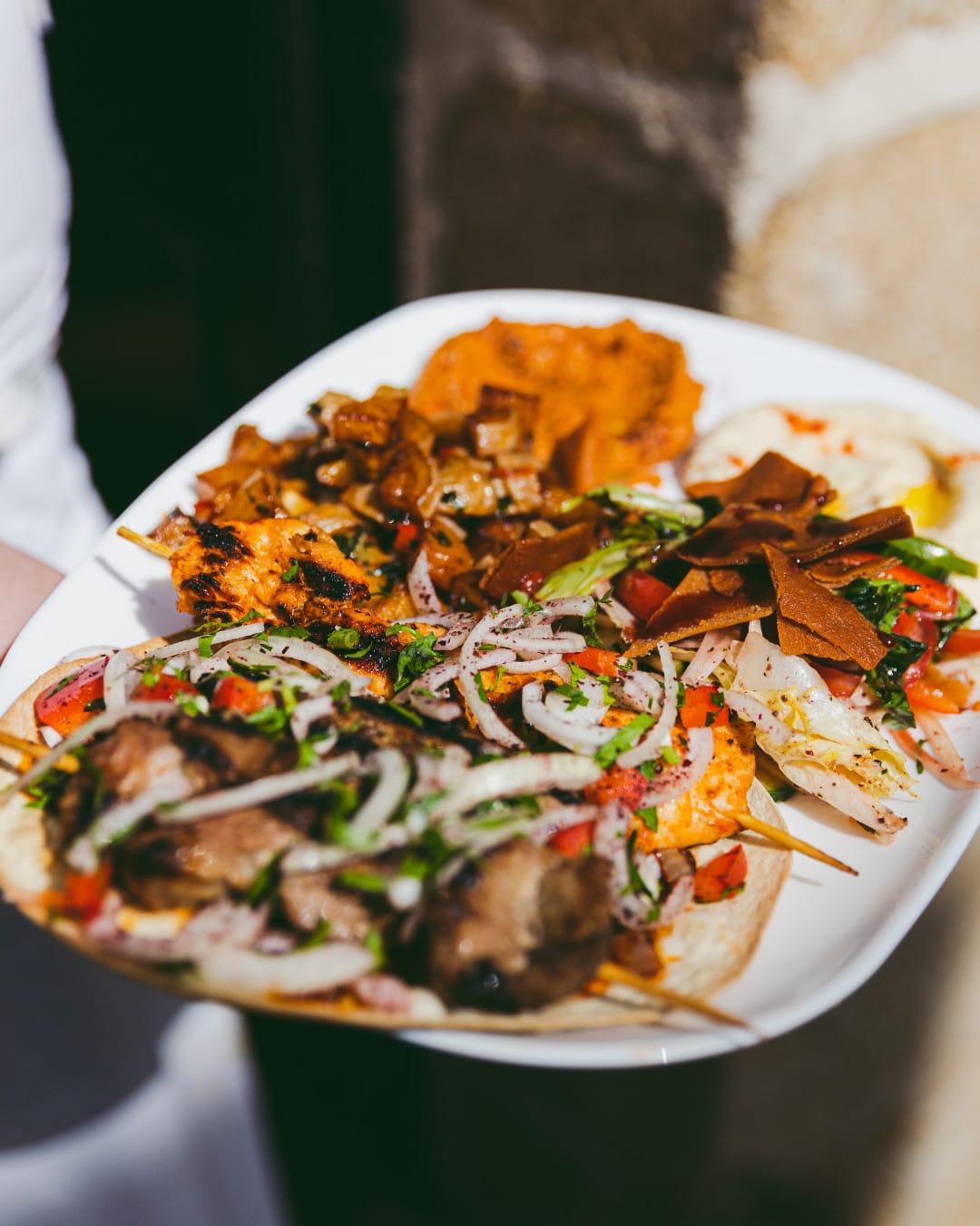 Plat composé libanais, grillades, mezzés et verres de vin sur table
