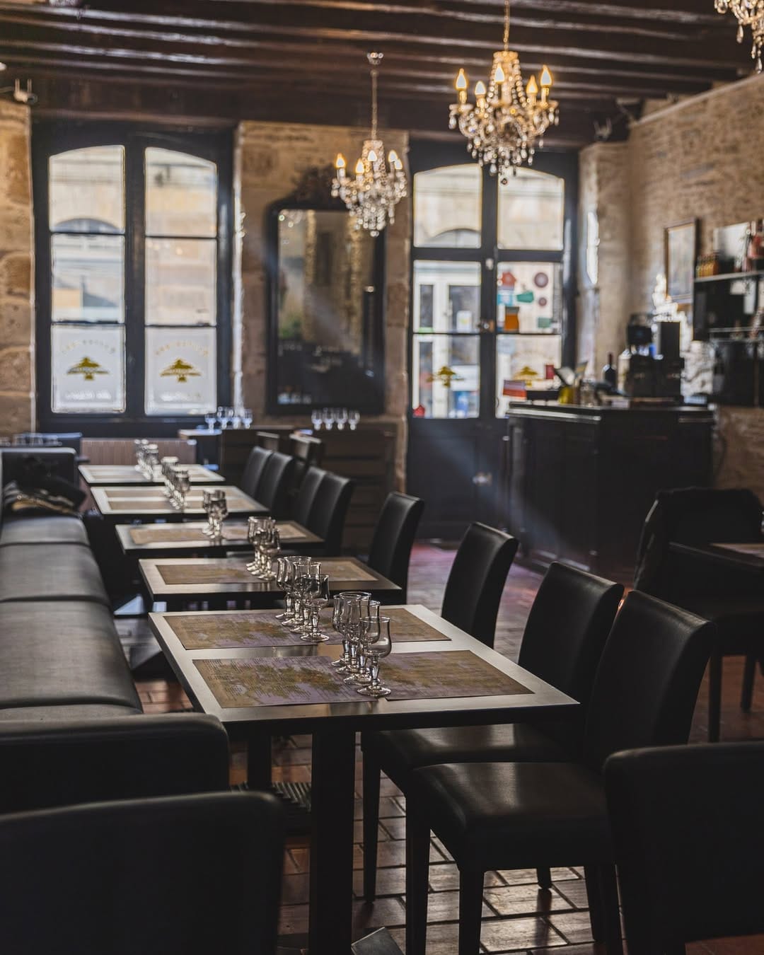 Salle du Cèdre rue Kervegan : tables dressées, lustres en cristal, plafond à poutres et murs en pierre