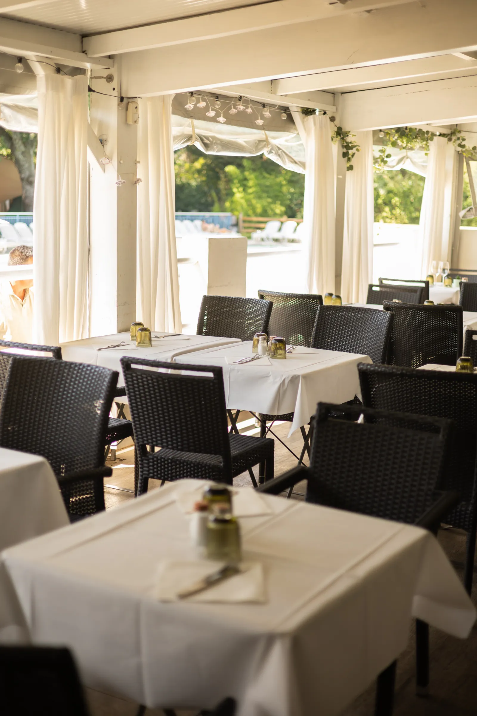 Terrasse couverte de La Paillote, tables dressées sous la tonnelle