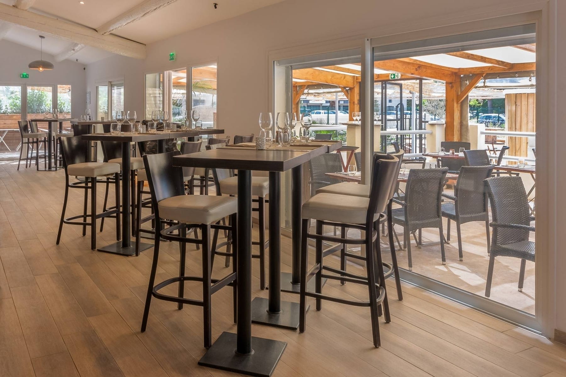 Salle ouverte sur la terrasse ombragée, prête pour un afterwork privatisé à La Paillote