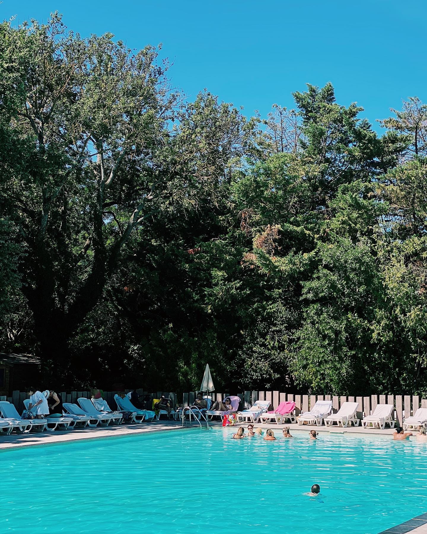 Baigneurs se détendant dans une piscine turquoise entourée de transats, ambiance pool party d’EVJF aux Milles