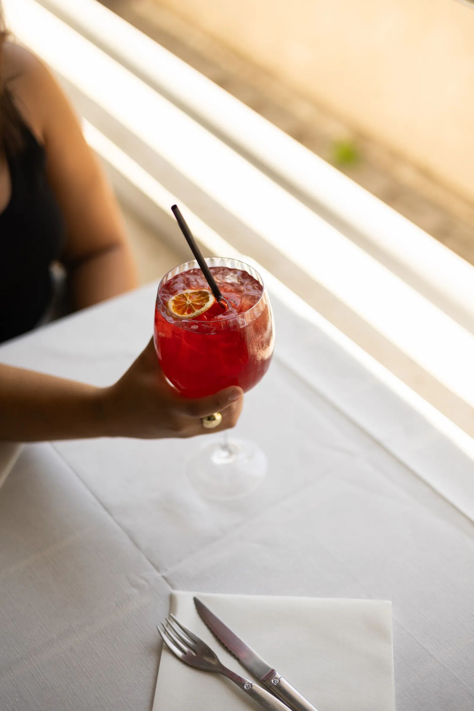 Cocktail de saison tenu au-dessus d'une table dressée