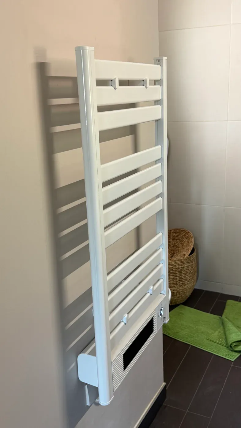 Sèche-serviettes blanc installé dans une salle de bain
