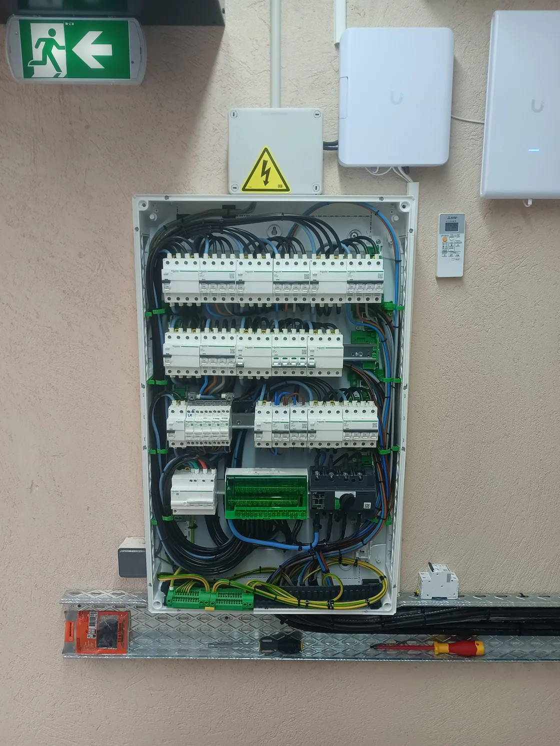 Tableau électrique ouvert, quatre rangées de modules.