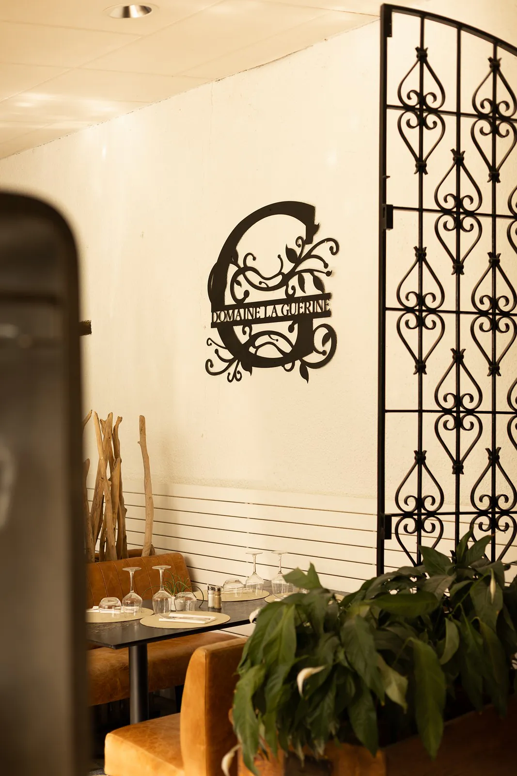 Le monogramme du domaine sur le mur de la salle, derrière une grille en fer forgé