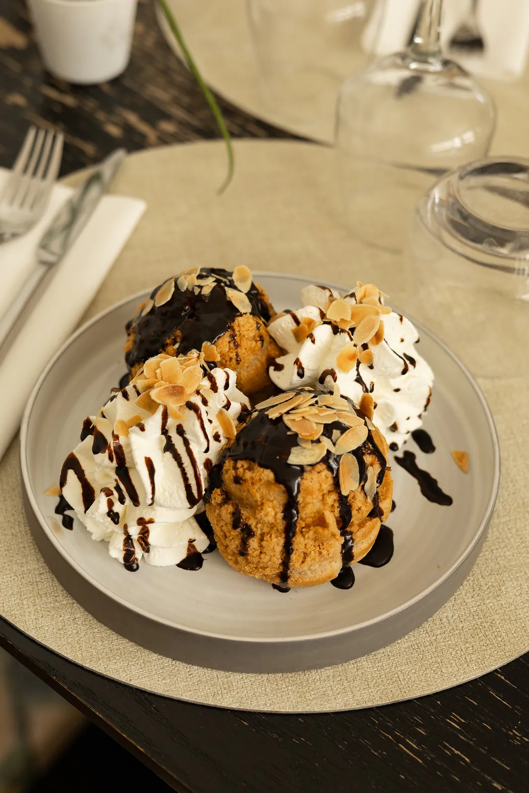Profiteroles : choux craquelin, glace vanille, sauce chocolat, chantilly et amandes grillées