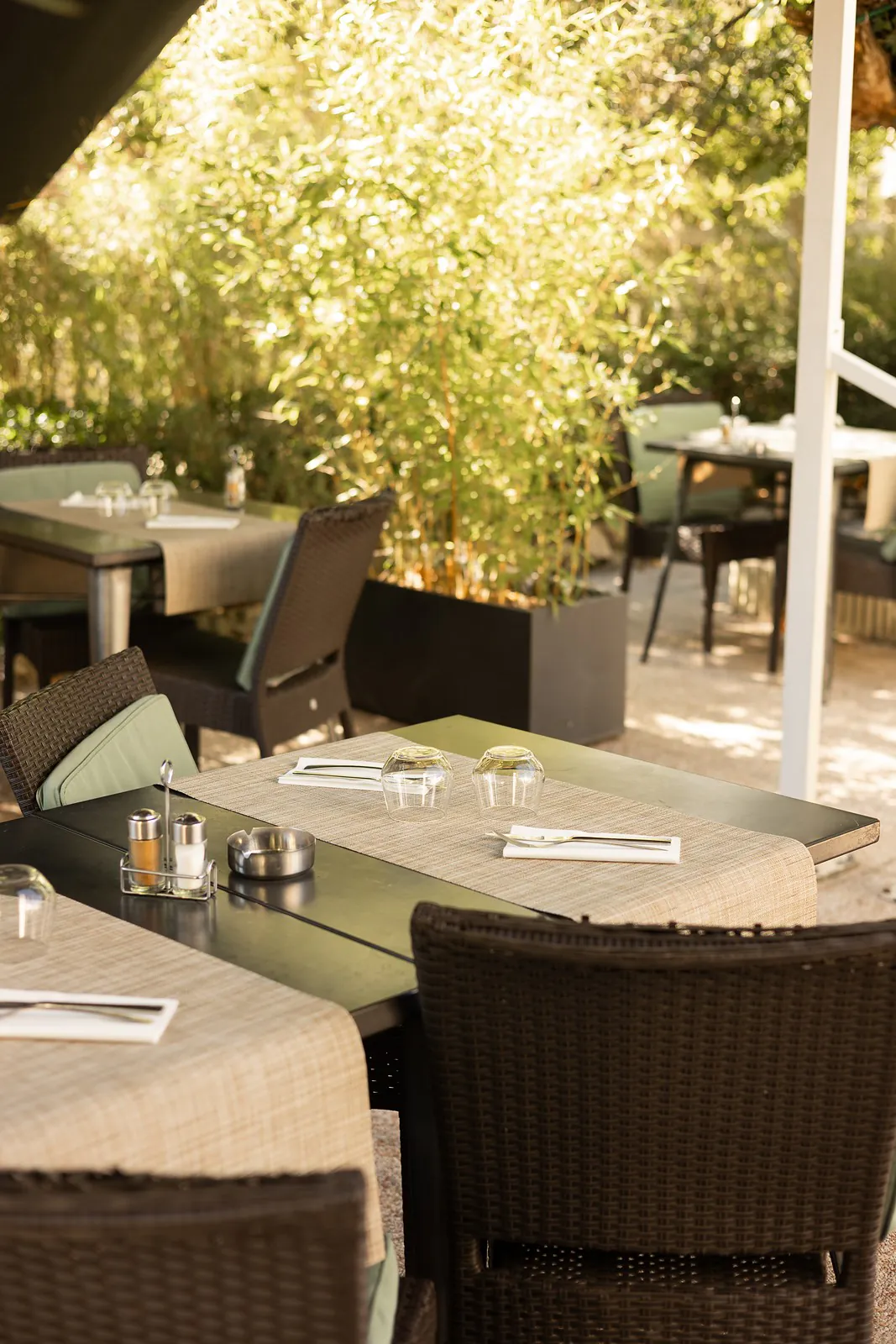 Tables dressées sur la terrasse, à l'ombre des bambous