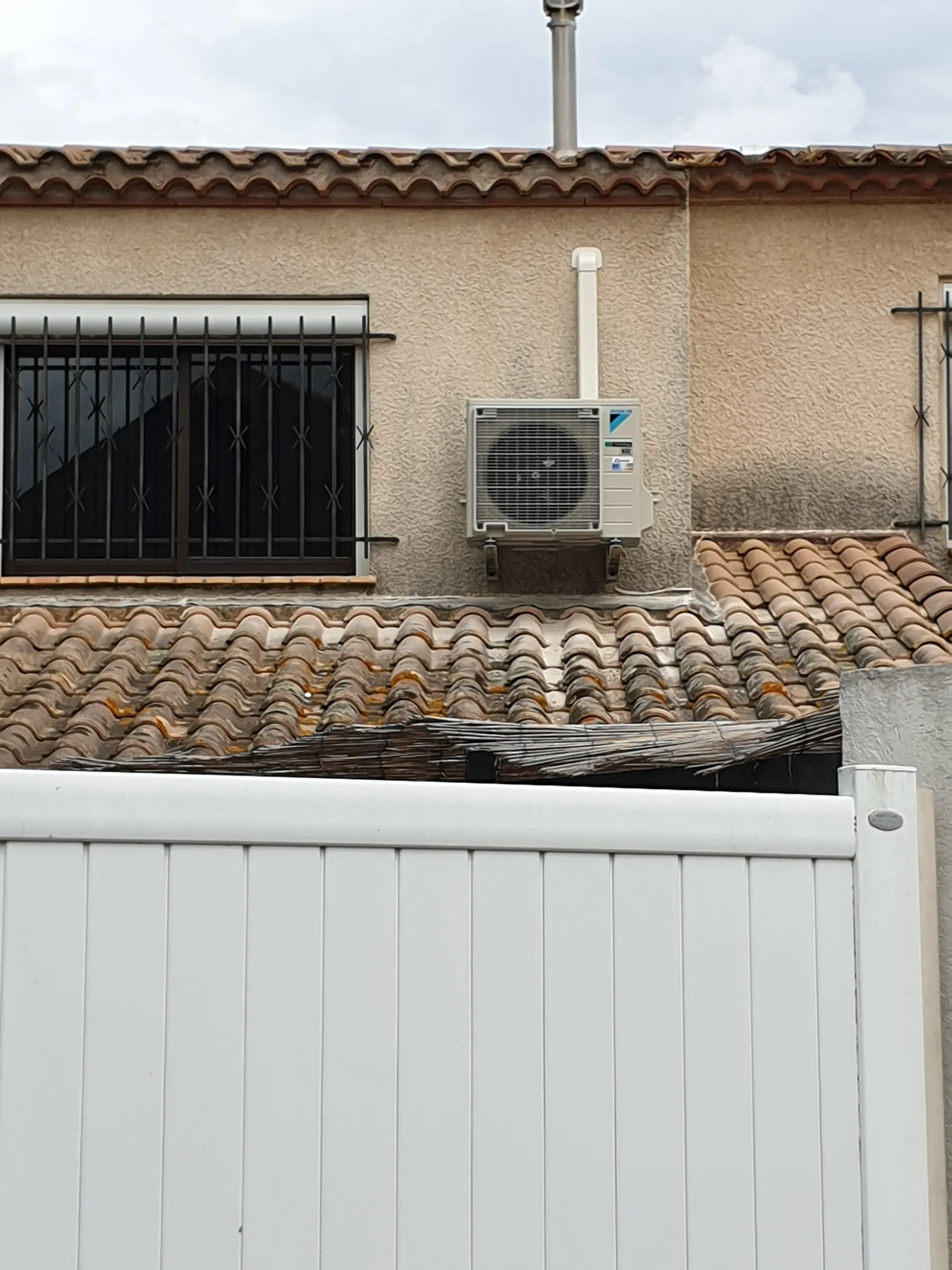 Unité extérieure de climatisation Daikin installée sur la façade d'une maison de l'Hérault