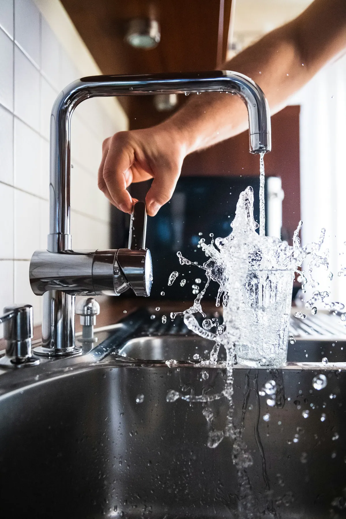Détail : main ouvrant un robinet