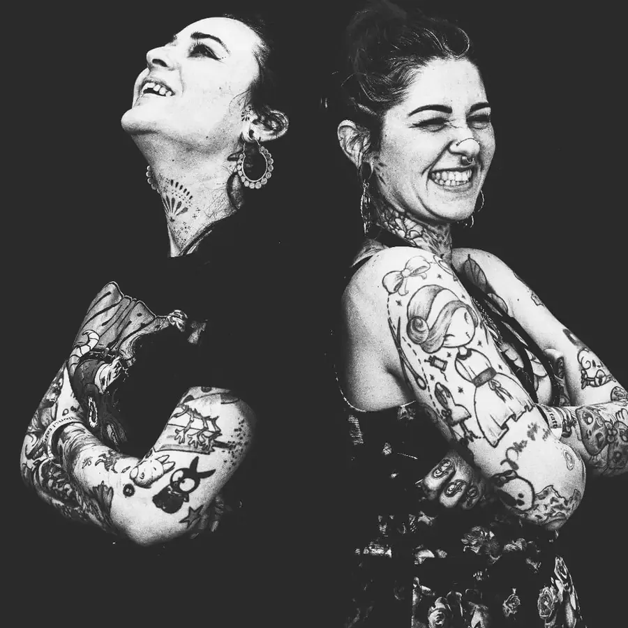 Wendy et Coline d'Ink Génération, dos à dos et souriantes, en noir et blanc