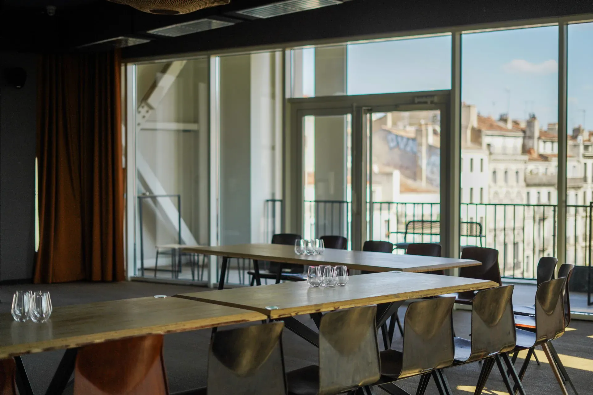 Salle du 3 en configuration repas, baies vitrées ouvertes sur Marseille