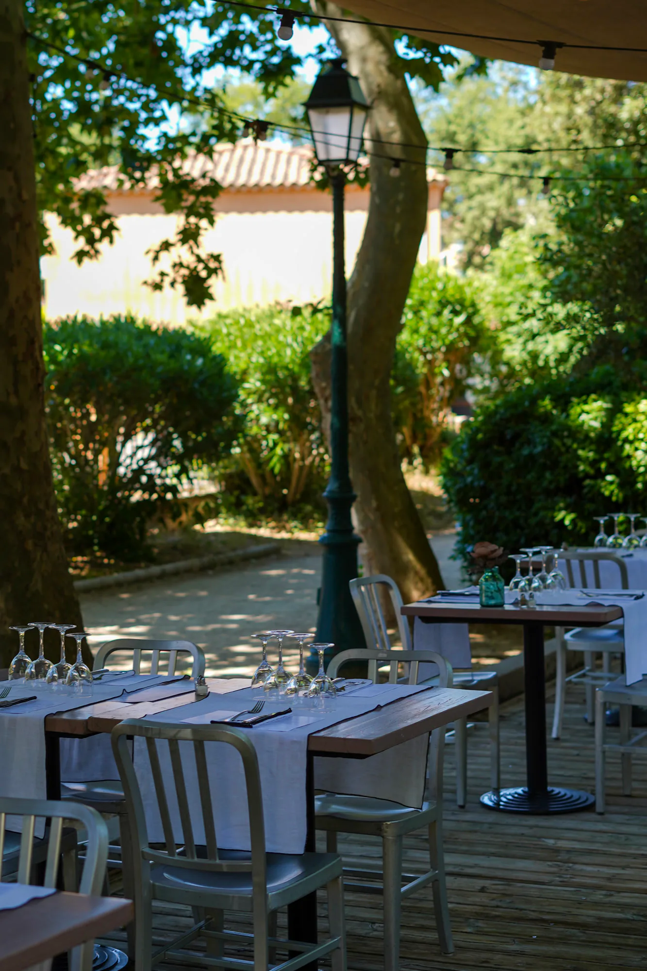 Tables dressées en terrasse ombragée à La Maison du Château, près d'Aix-en-Provence