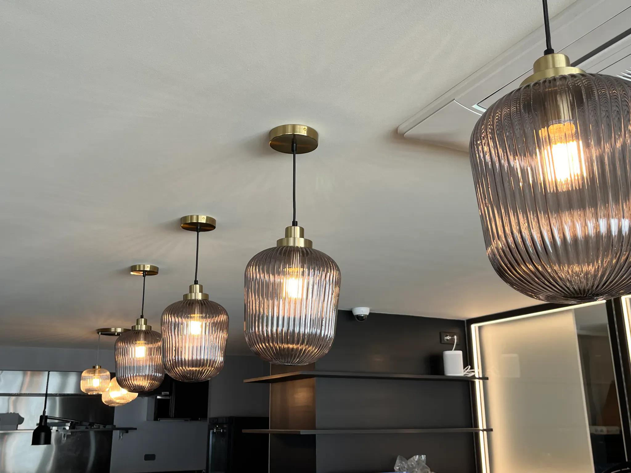Suspensions en verre côtelé fumé et laiton au-dessus d'un plan de service