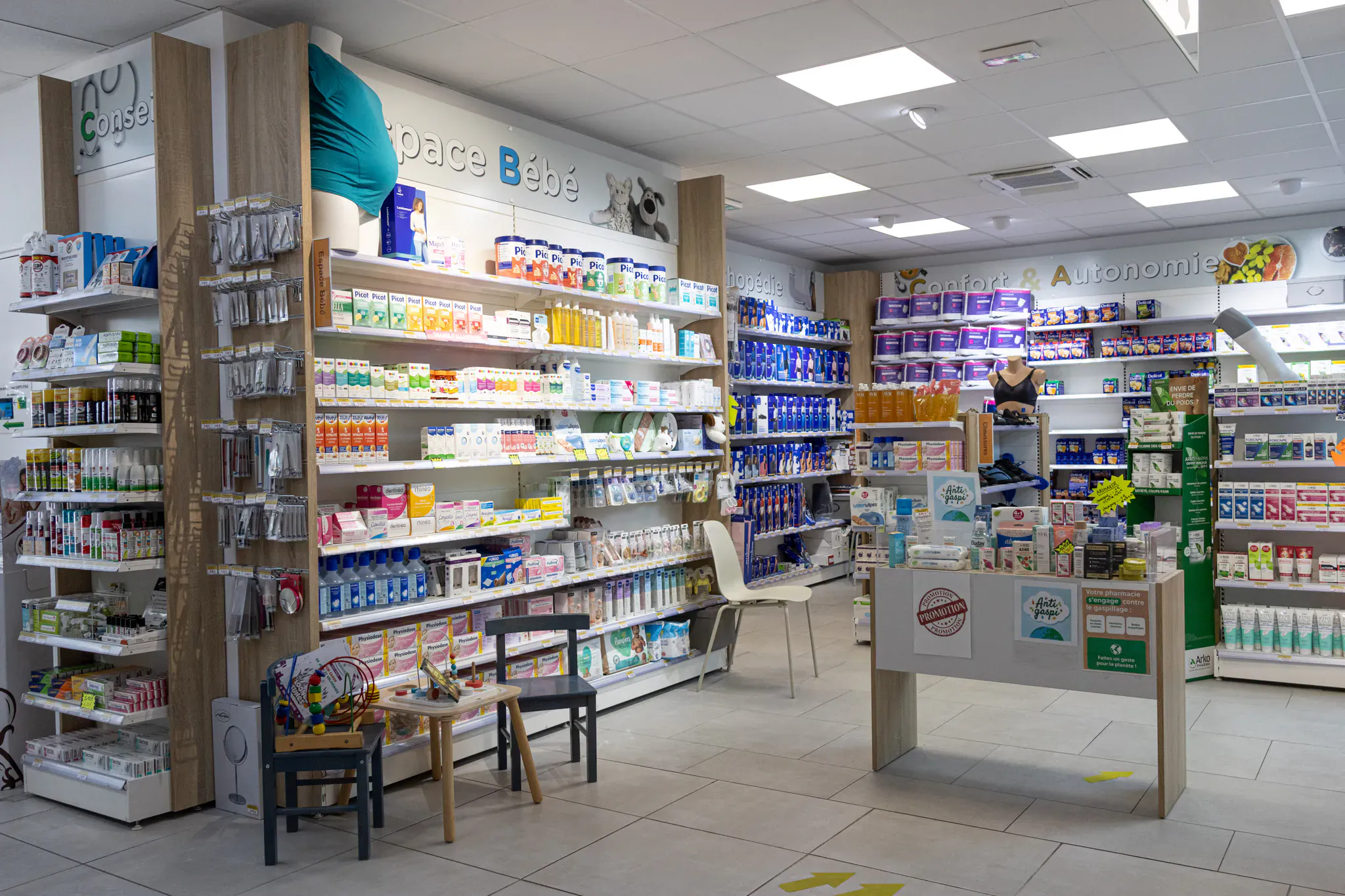 Rayons d'une pharmacie organisés par espaces thématiques après rénovation de la devanture
