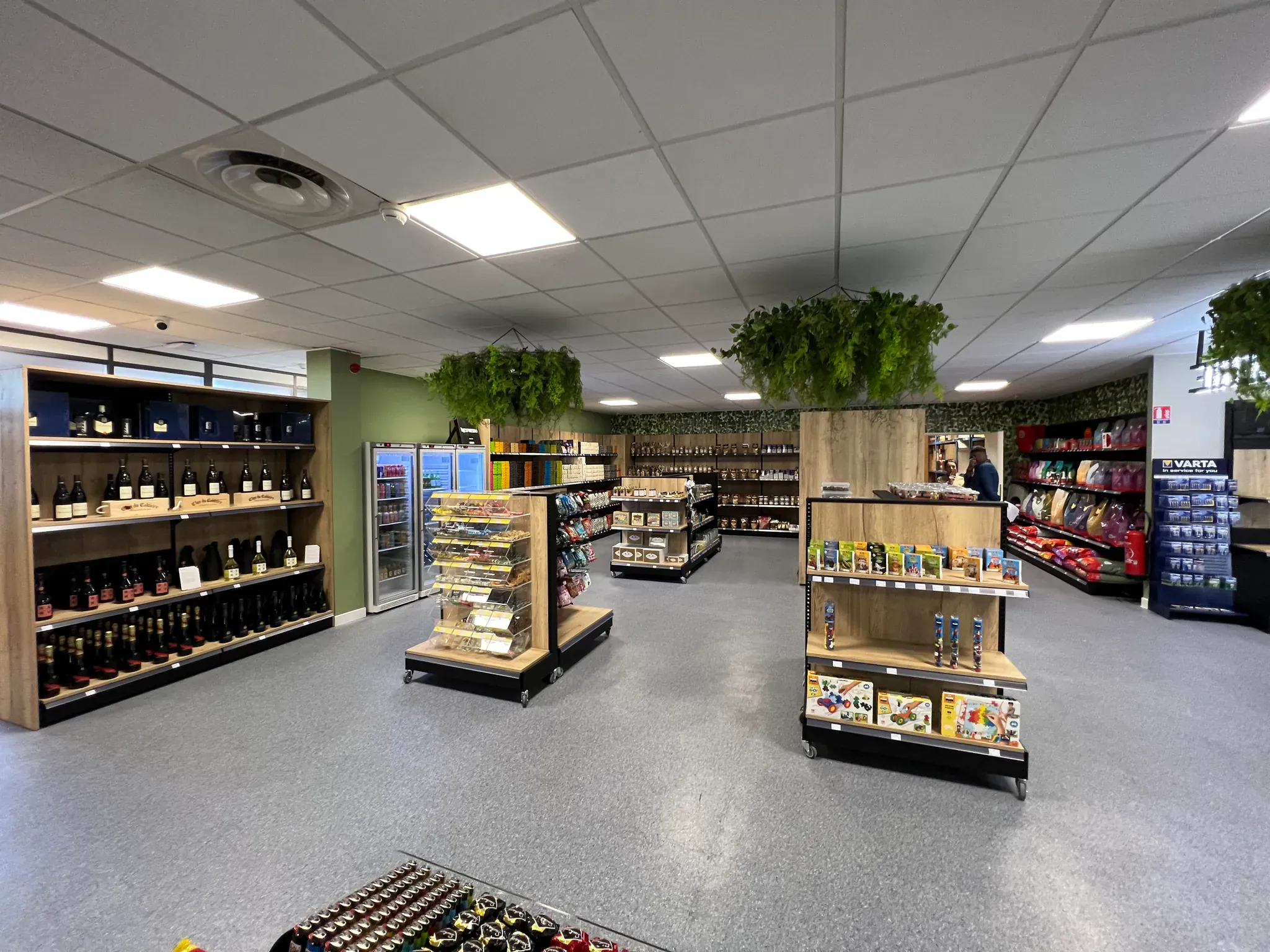 Supérette de proximité bien agencée avec rayons d'épicerie et de vins
