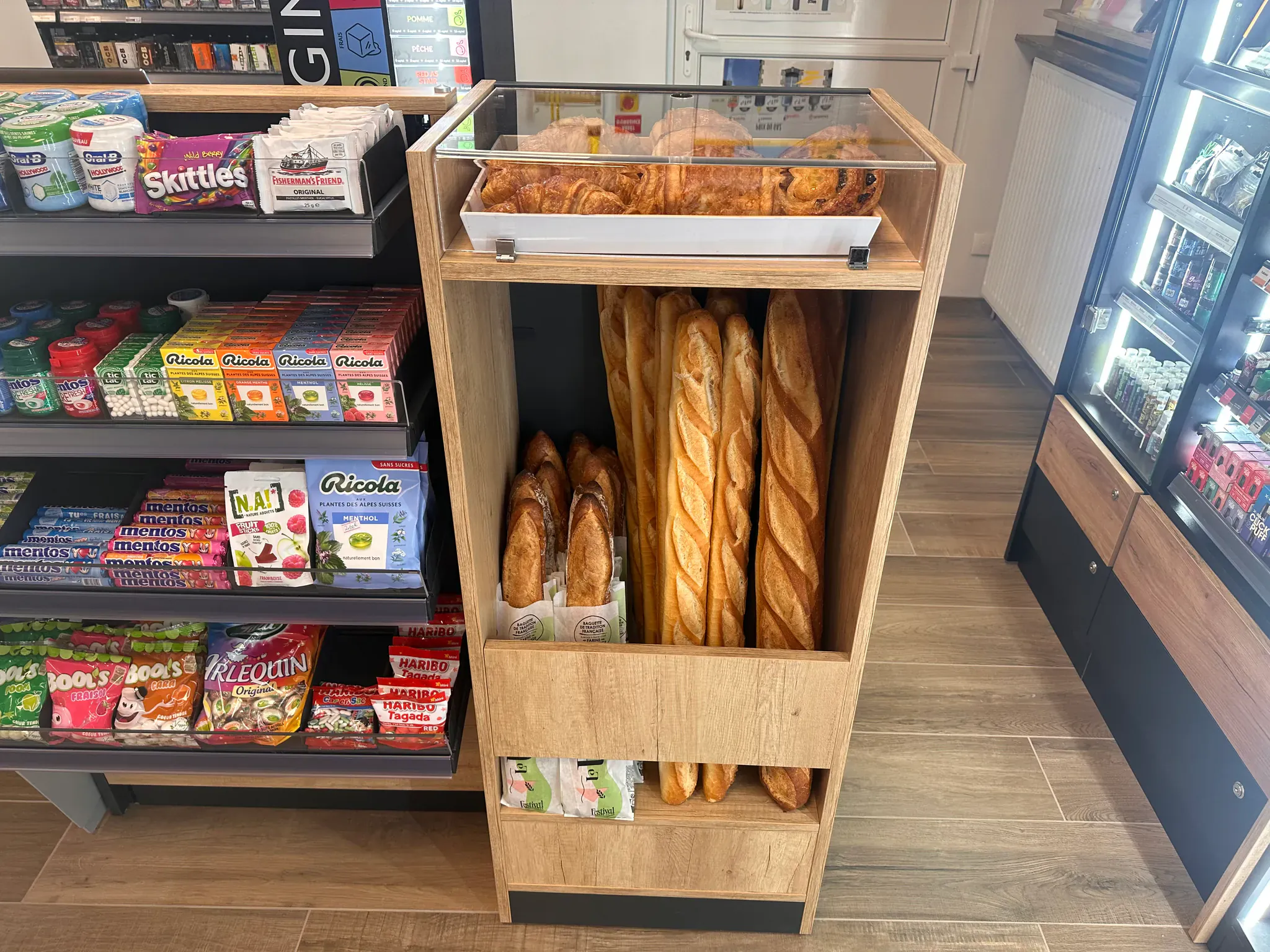 Présentoir en bois de baguettes et viennoiseries dans un commerce de proximité