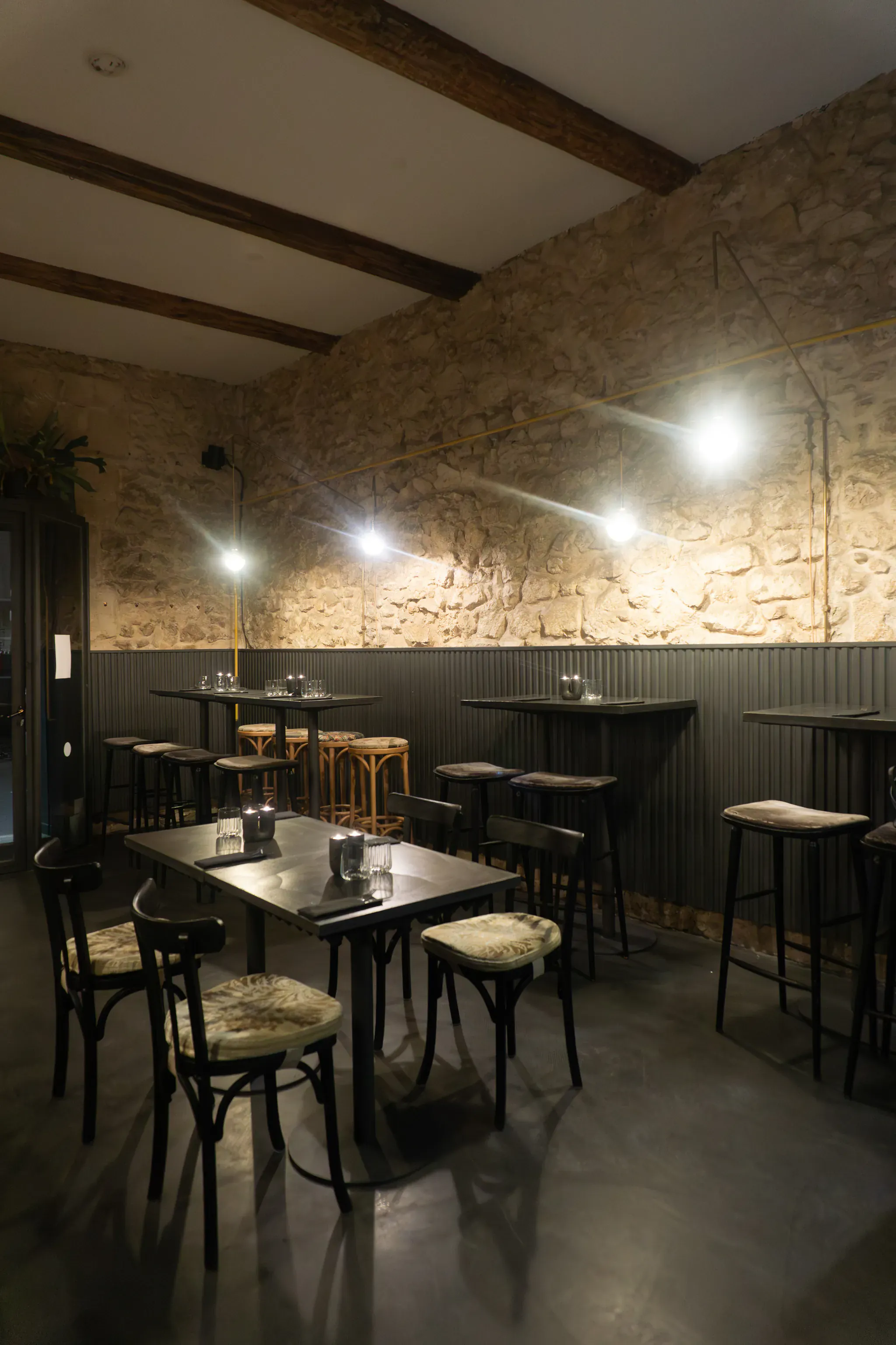 Salle de restaurant au style rustique-chic avec mur en pierre et tables dressées chez mon amour