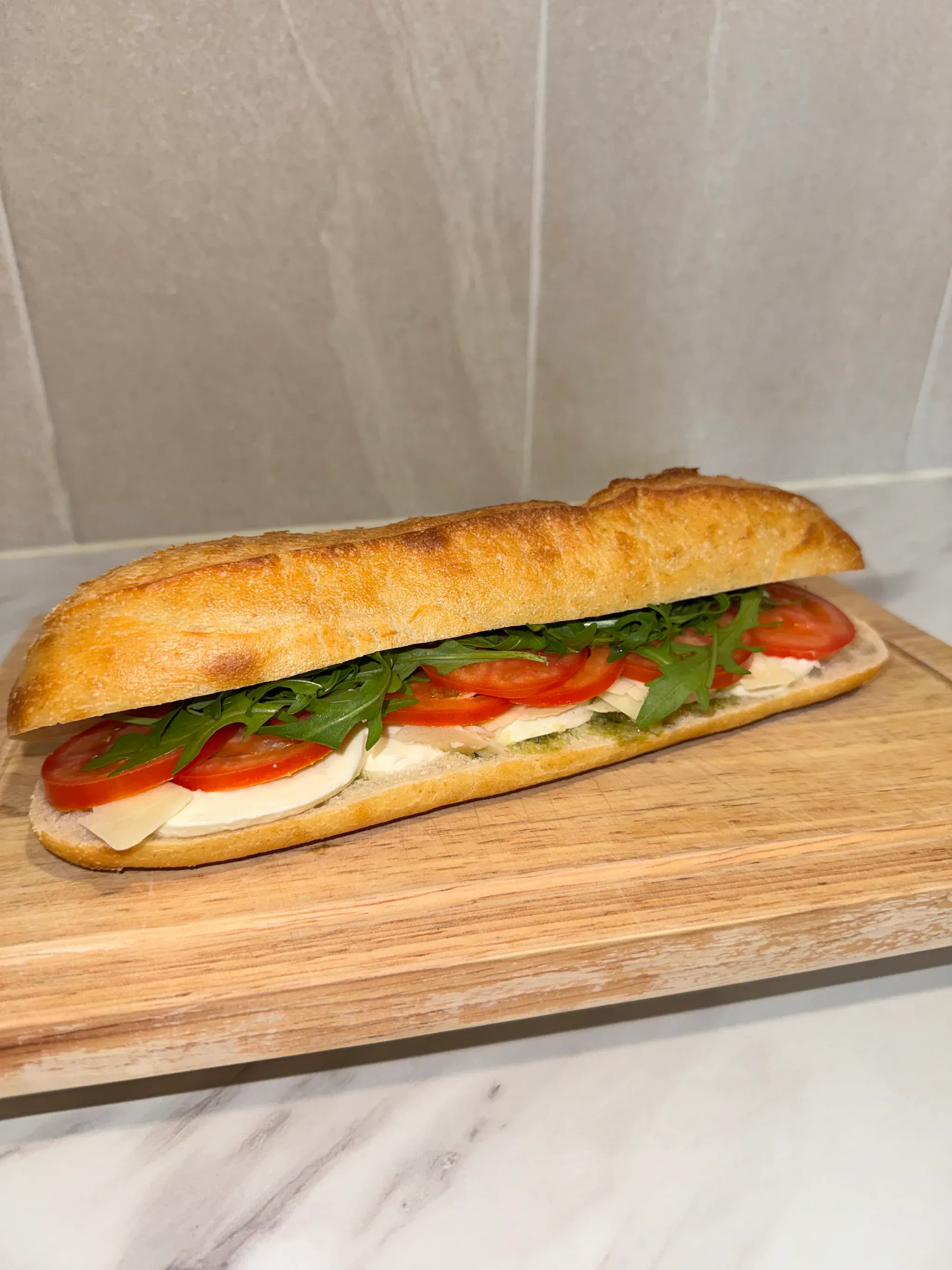 Sandwich baguette italien garni de mozzarella, tomate, roquette et pesto pour un afterwork d'entreprise