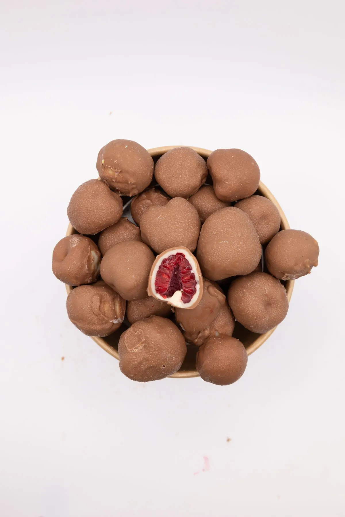 Macro d'un pot de framboises enrobées de chocolat au lait