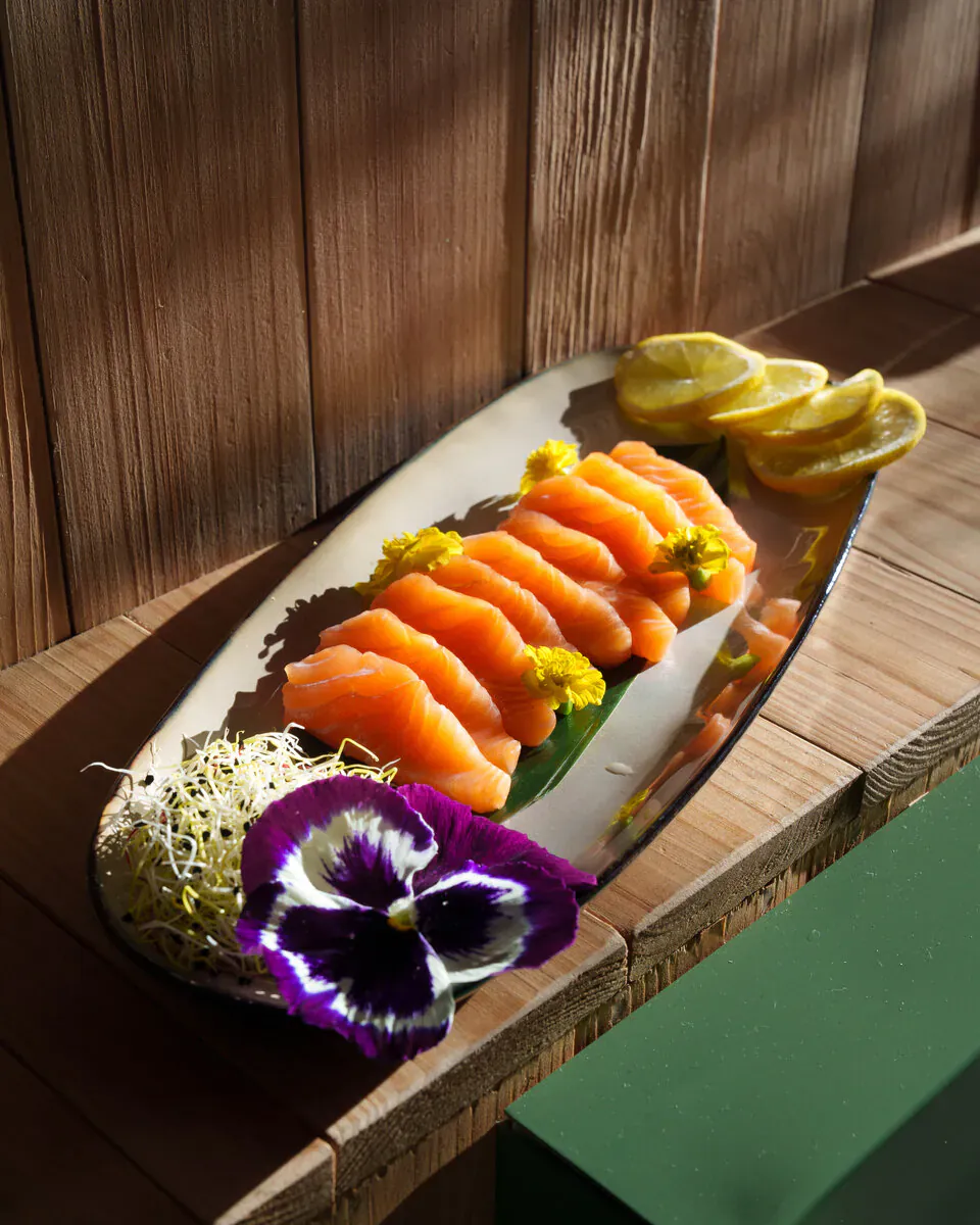 Sashimi de saumon finement tranché, dressé pour révéler ses arômes à température