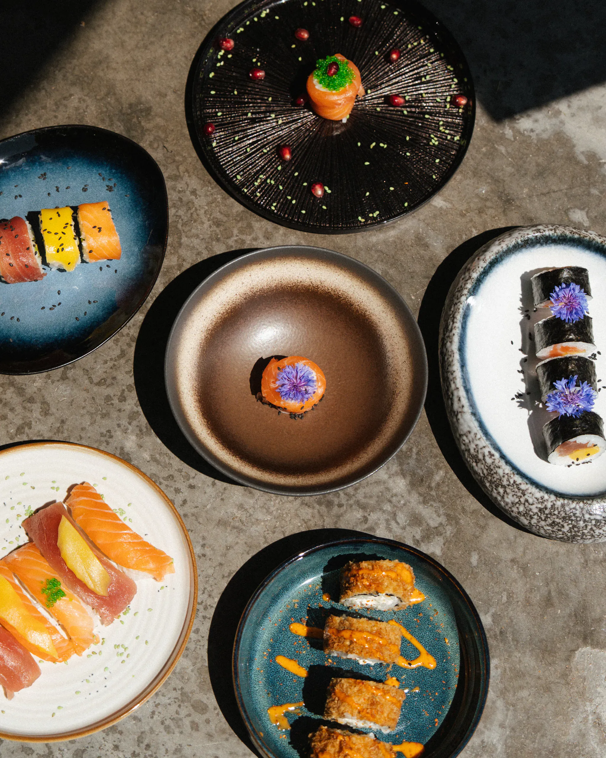 Assortiment de sushis et makis créatifs présentés sur des assiettes en céramique