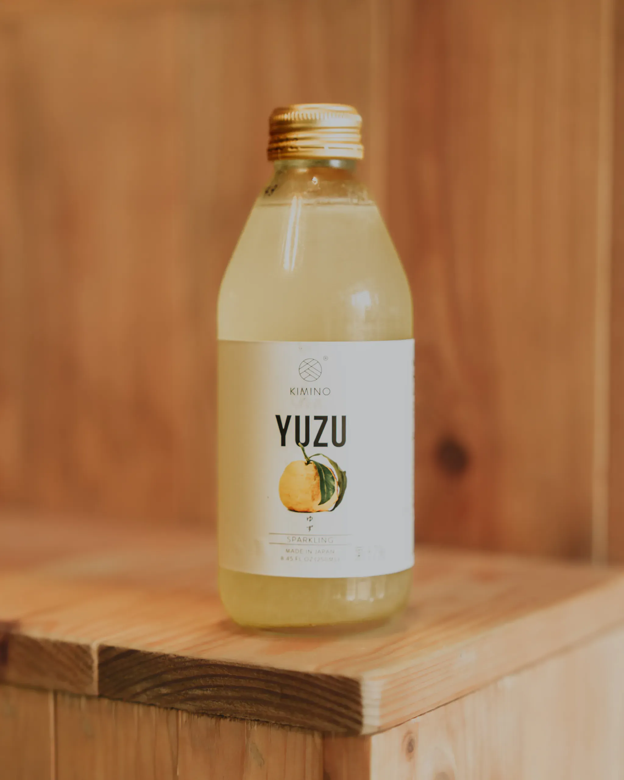 Bouteille de boisson pétillante japonaise au yuzu posée sur une caisse en bois, une boisson qui accompagne un repas végétarien