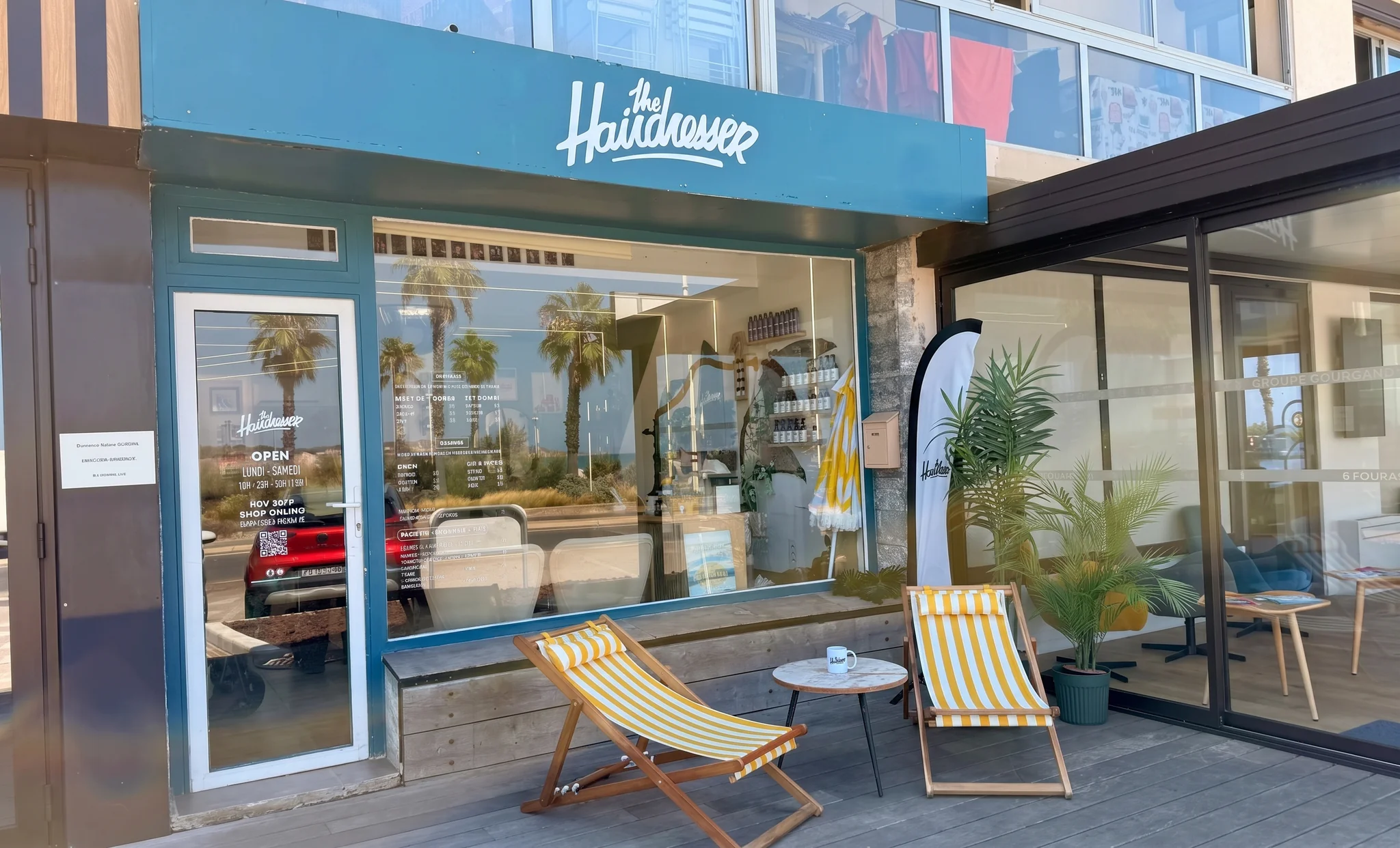 La devanture bleue de The Hairdresser, avec deux transats rayés jaune et blanc sur la terrasse en bois