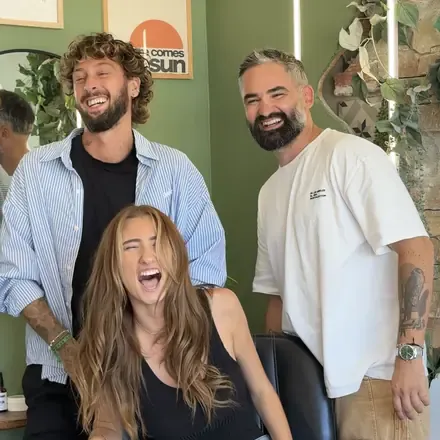 L’équipe du salon en train de rire, devant le mur vert