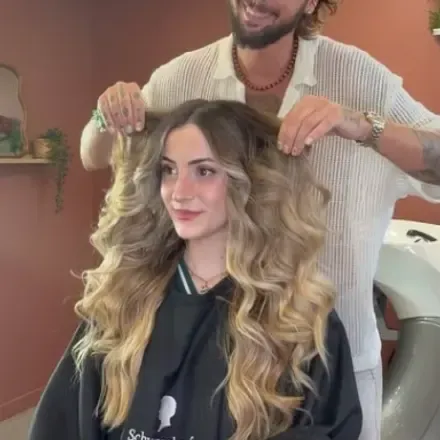 Coiffeur présentant un balayage blond ondulé