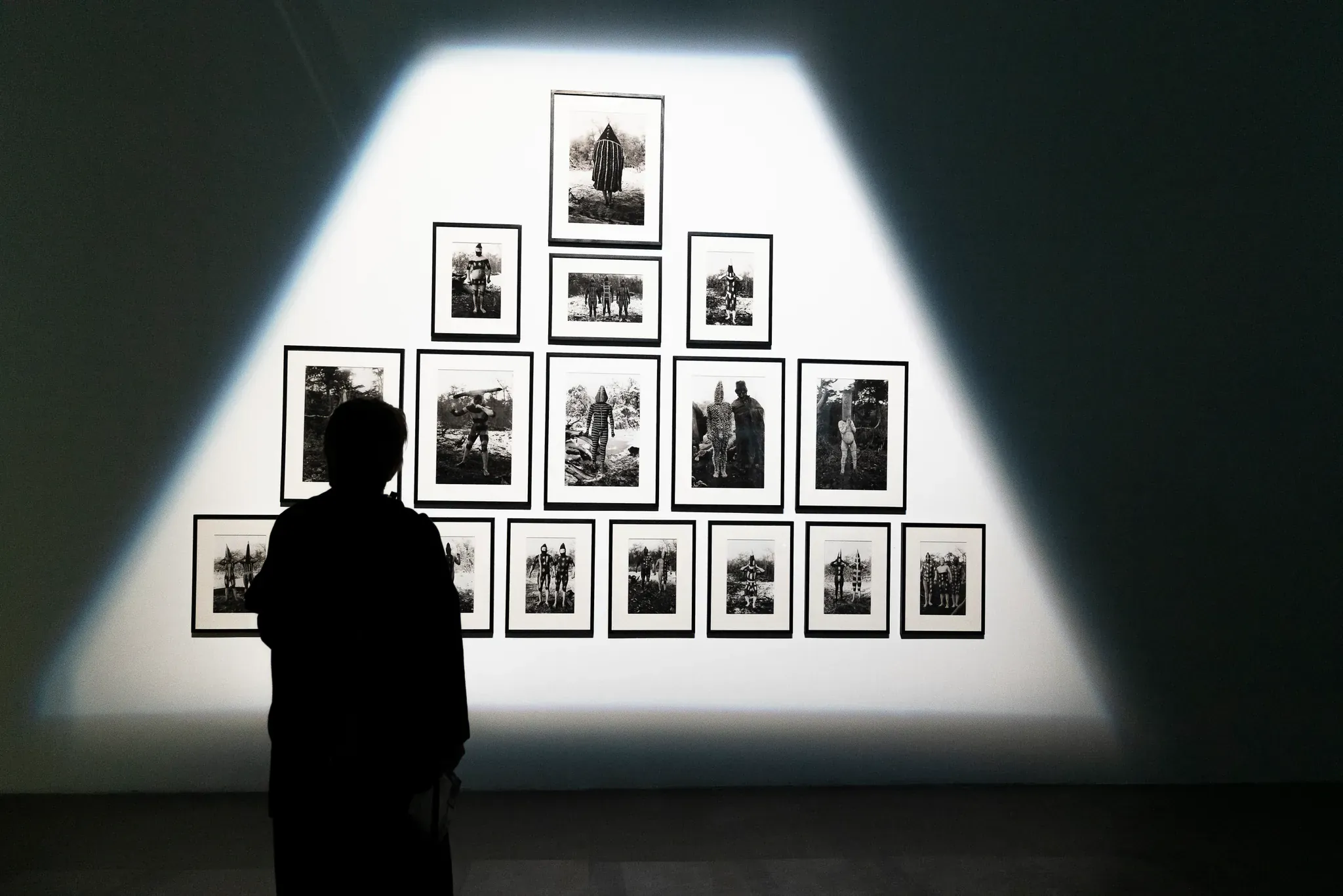 Visiteur observant un mur d'exposition photographique, le regard documentaire de notre boîte de production