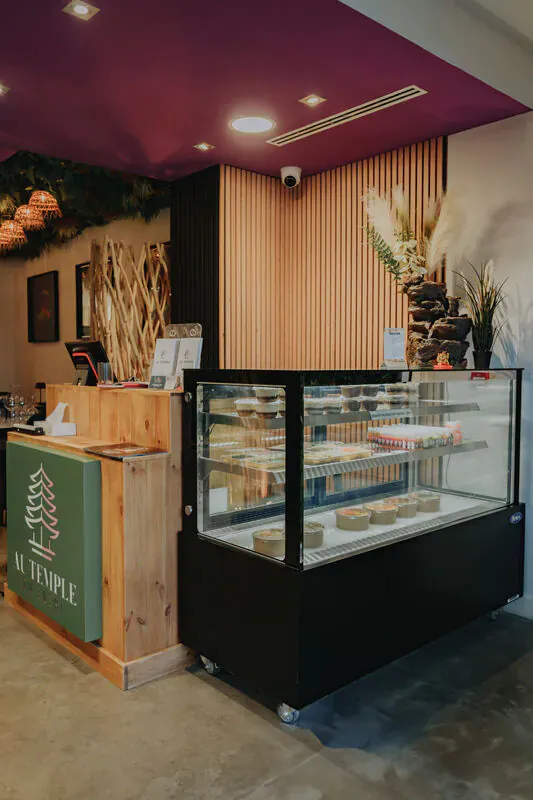Intérieur chaleureux d'une épicerie italienne de proximité, comptoir en bois et vitrine réfrigérée