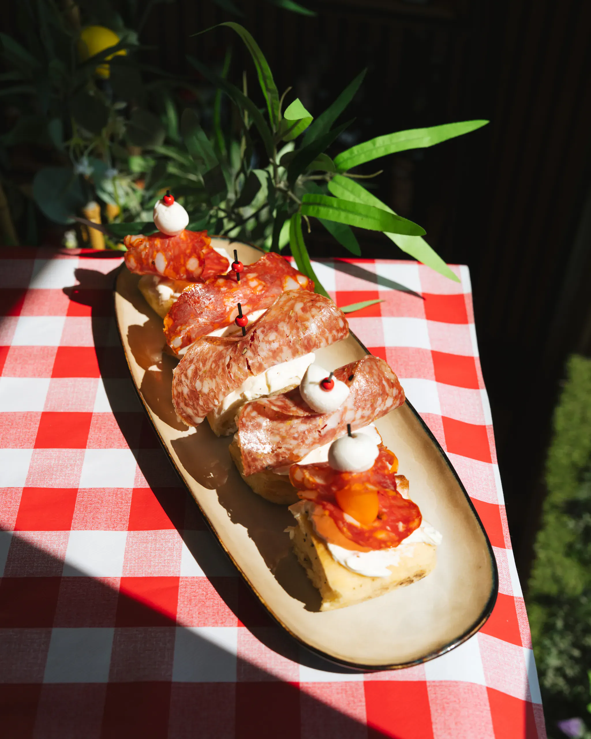 Bruschettas au fromage frais et charcuterie italienne servies en antipasti