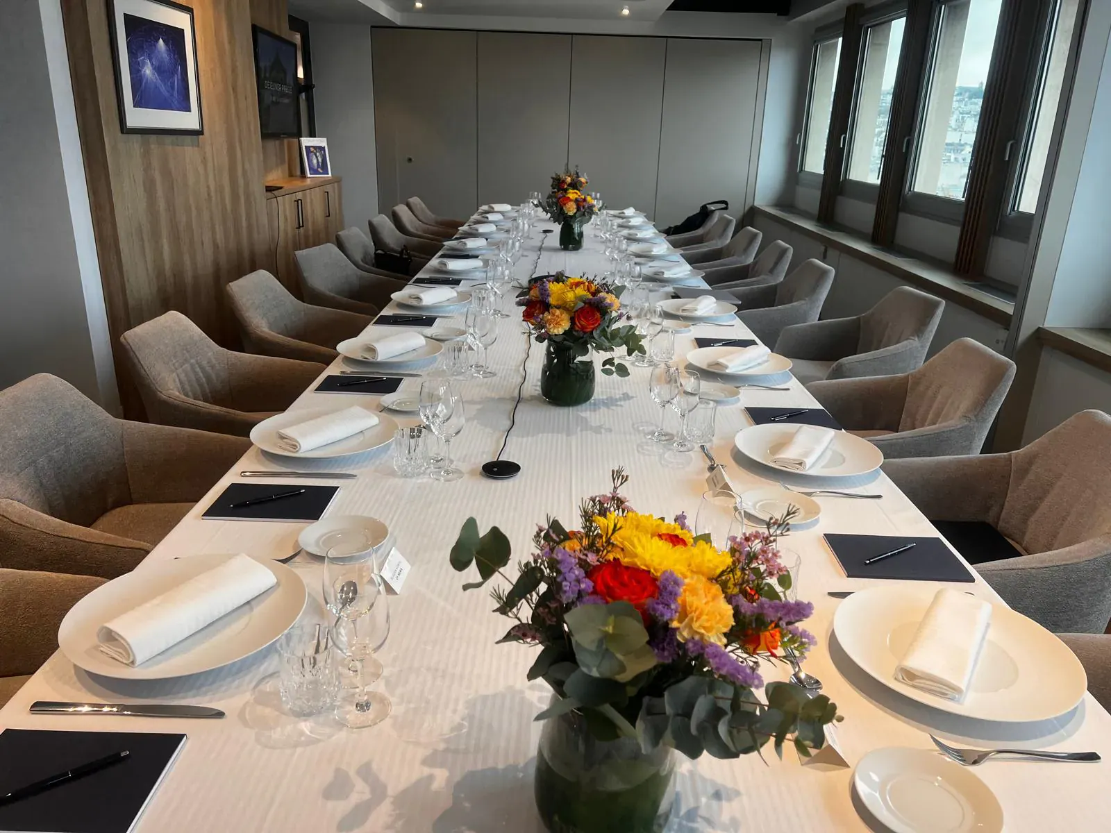 Longue table dressée pour un événement d'entreprise, illustrant la coordination du jour J