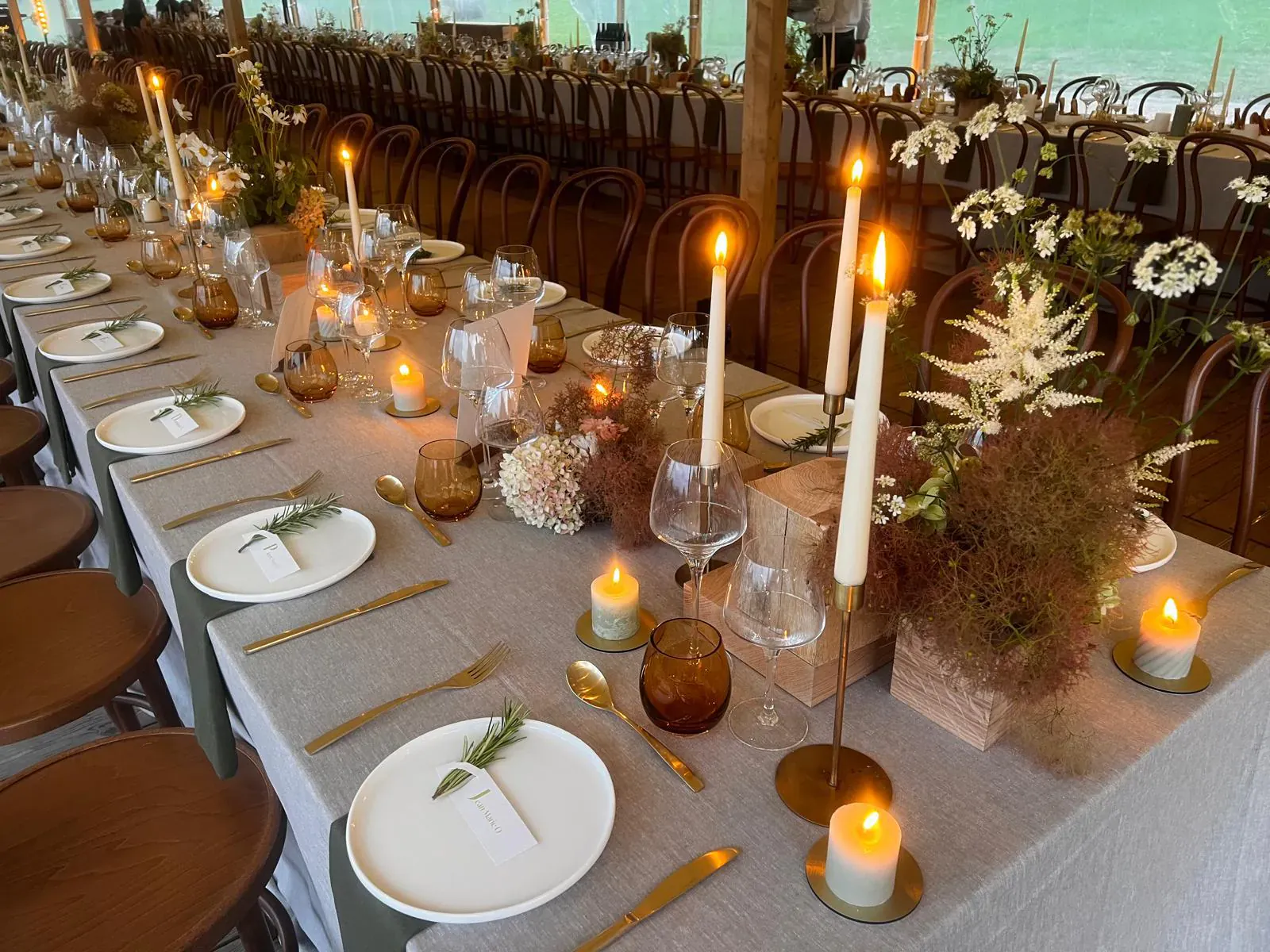 Longue table de mariage dressée sous une tente dans le parc privatisé d'un domaine