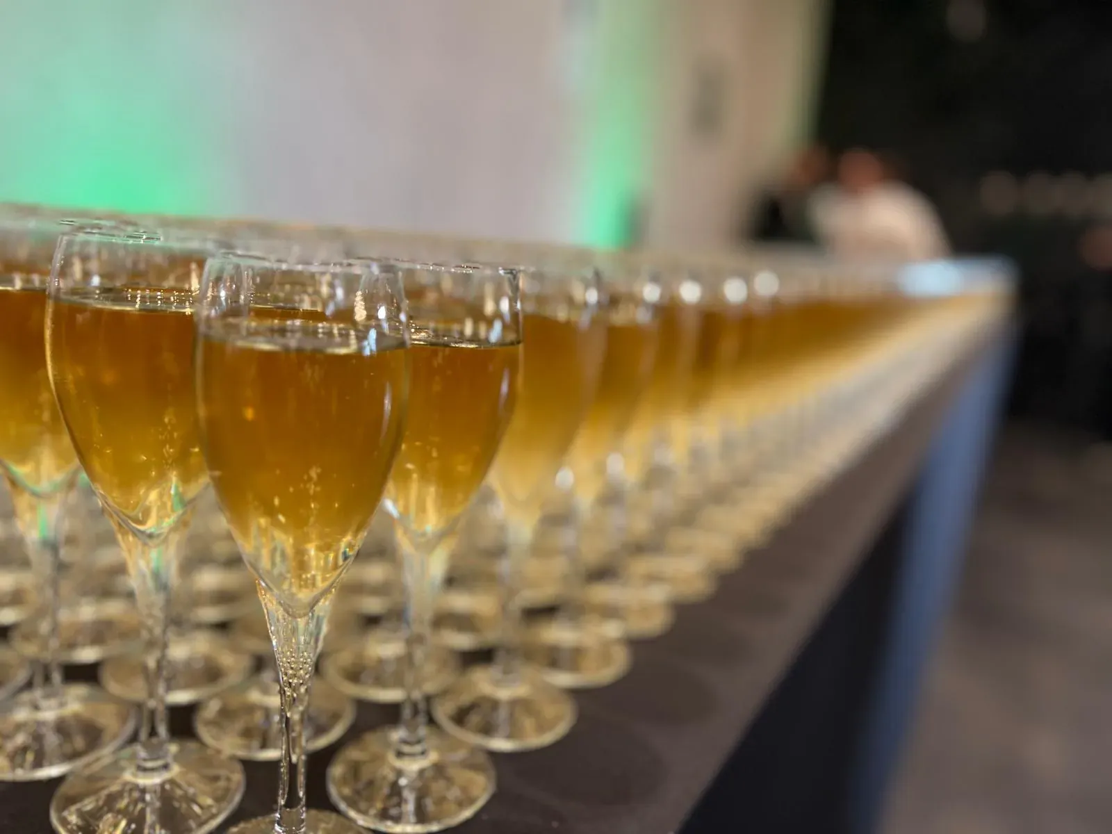 Coupes de champagne alignées pour un cocktail de soirée d'entreprise coordonné par une agence
