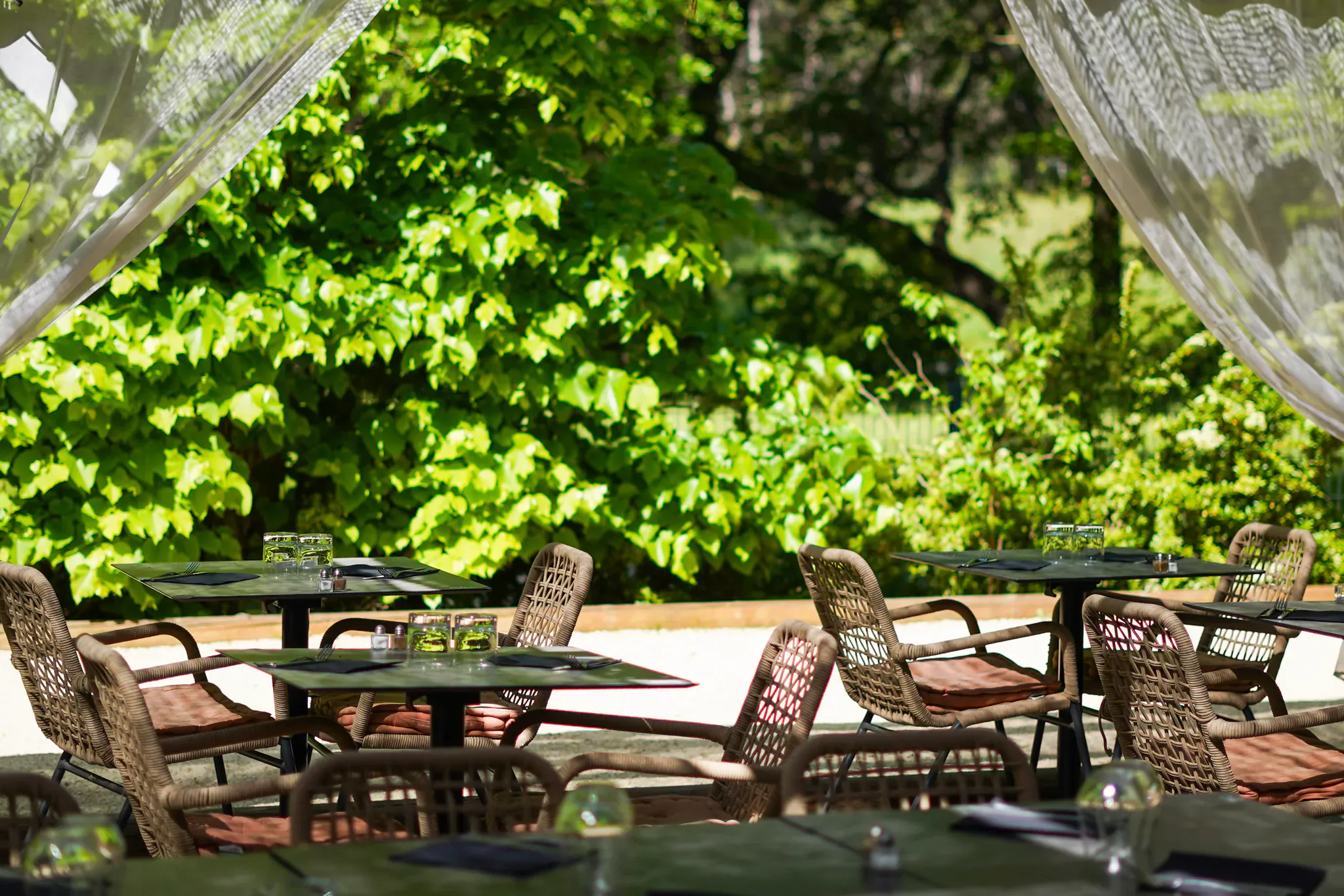 Terrasse de restaurant à Vitrolles dressée pour un repas de groupe, entourée de verdure