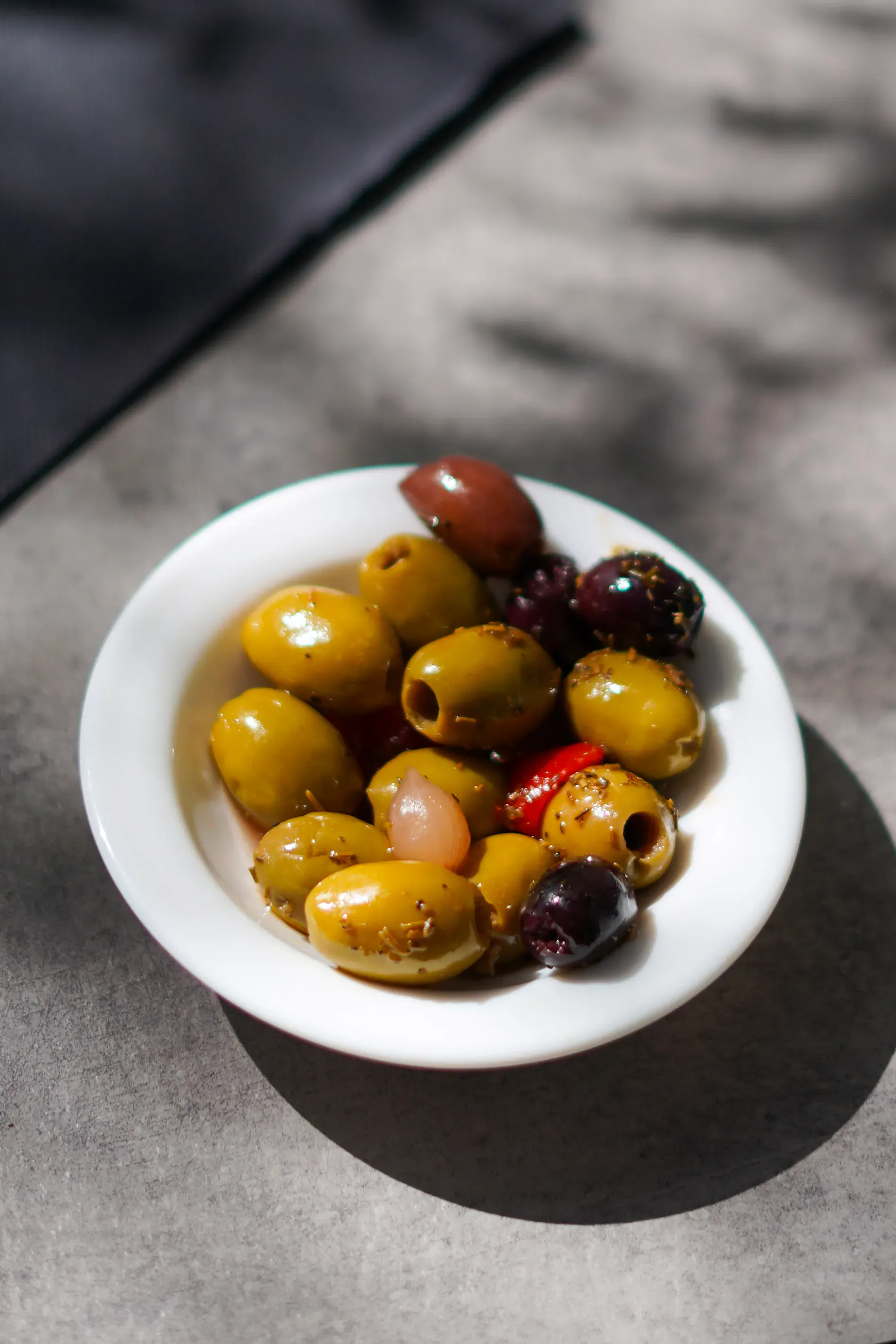 Bowl of marinated green and black olives with herbs, as an apéritif at Le Millésime in Vitrolles