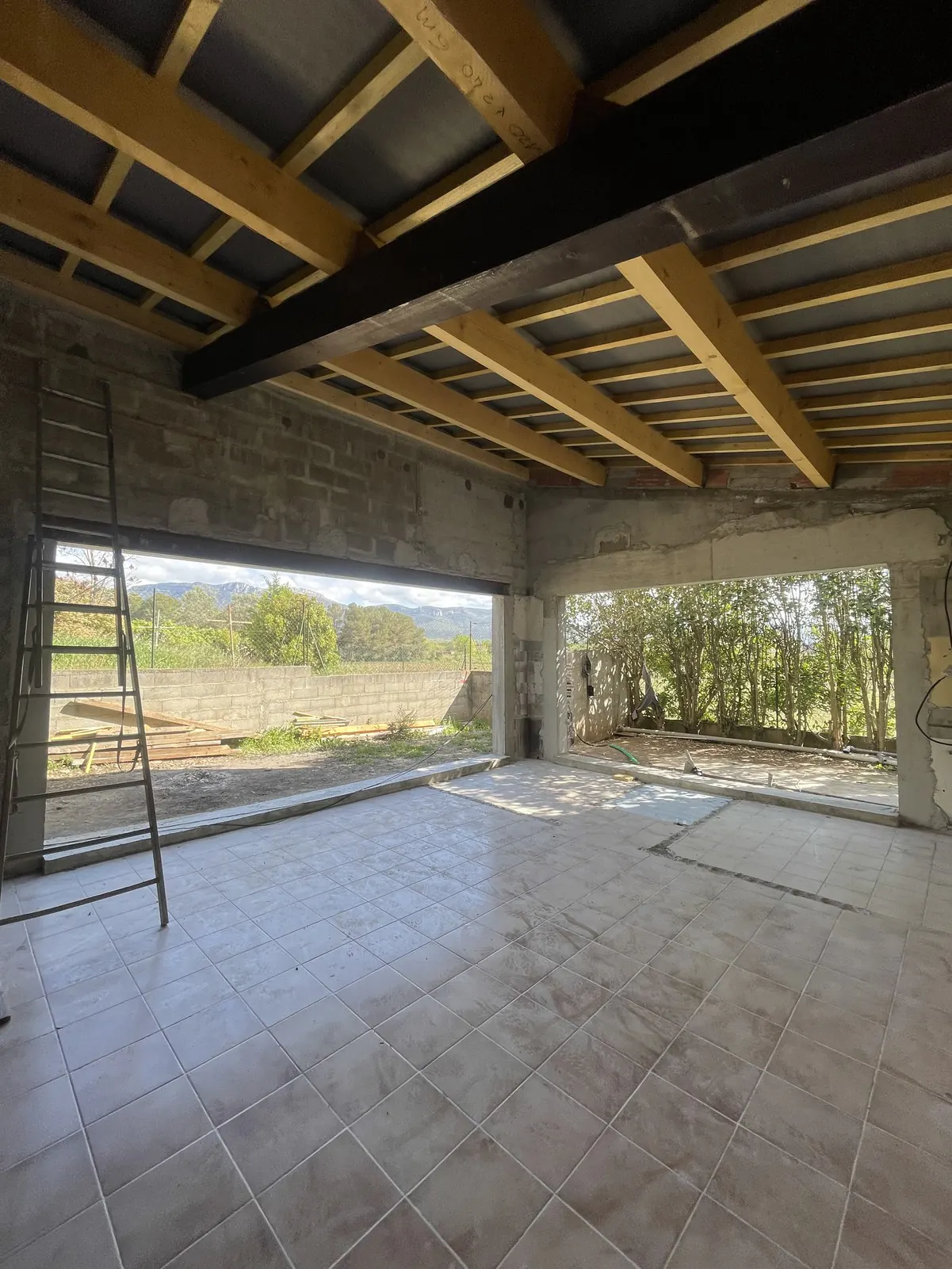 Pièce à vivre sous la nouvelle charpente en bois, ouverte sur le jardin