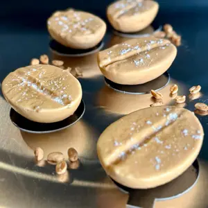 Création trompe-l'œil cacahuète à la fleur de sel, posée parmi des cacahuètes décortiquées