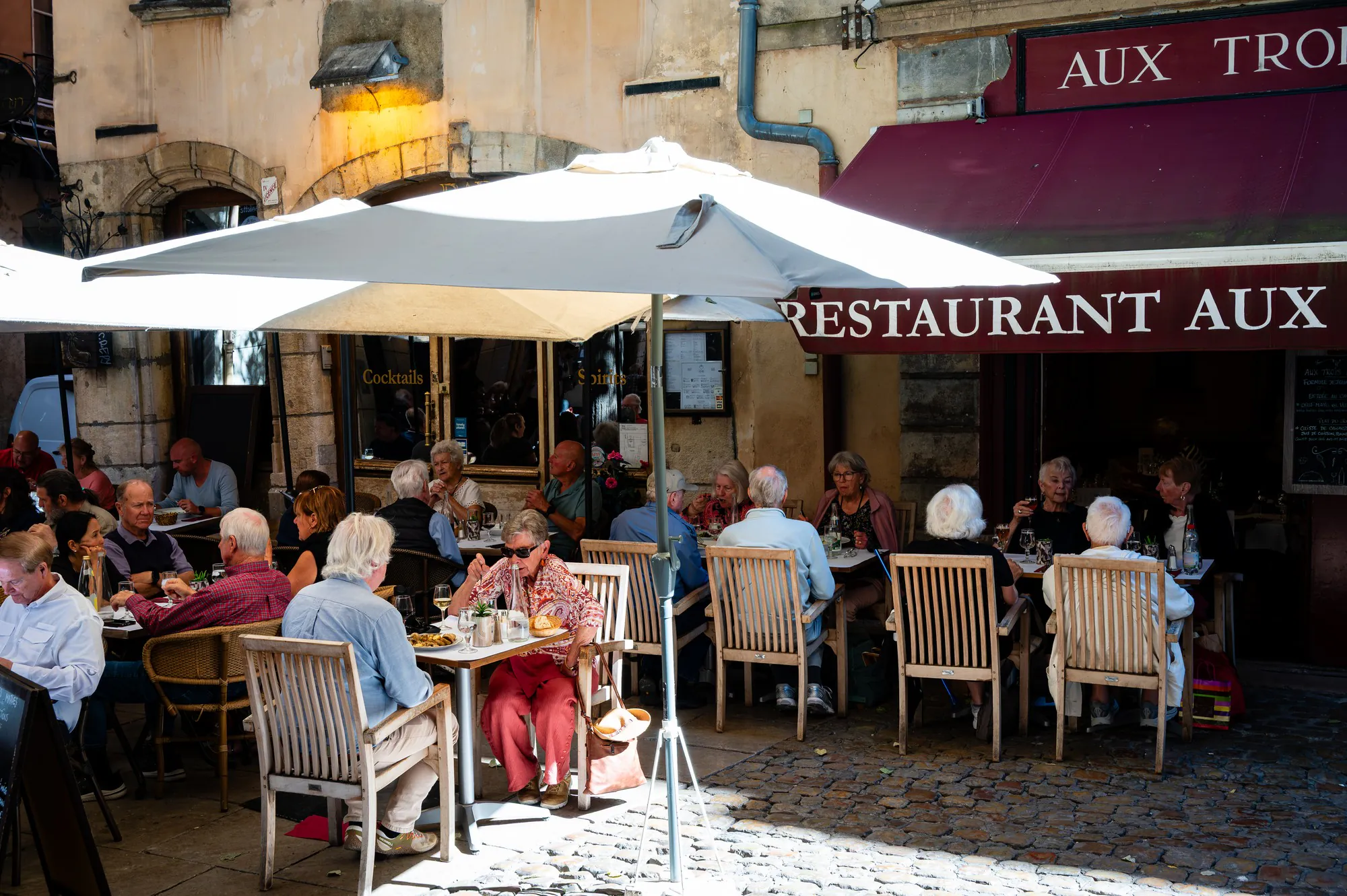 Restaurant terrace set with white linen in a street of old Lyon