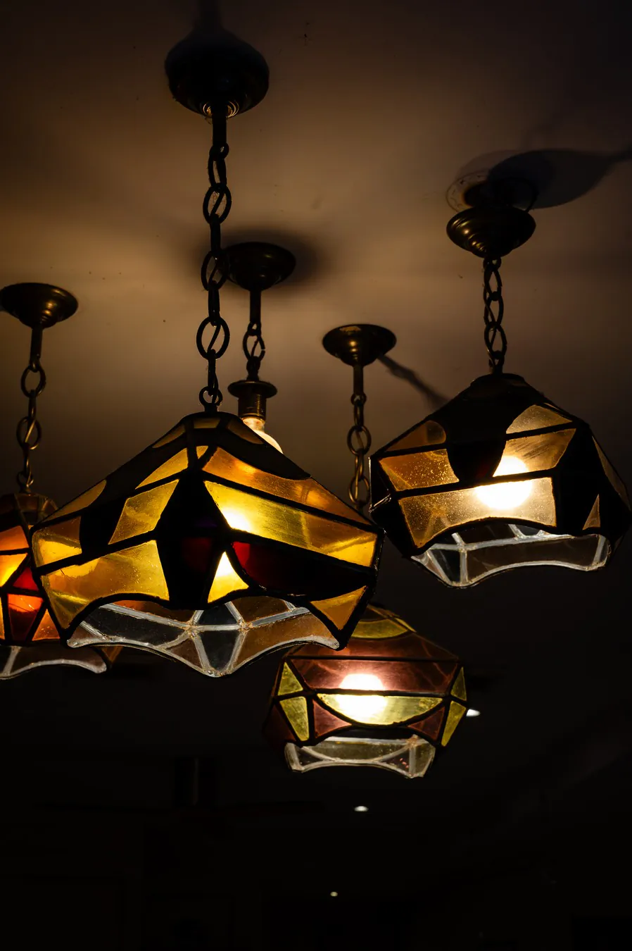 The coloured-glass pendant lights, switched on