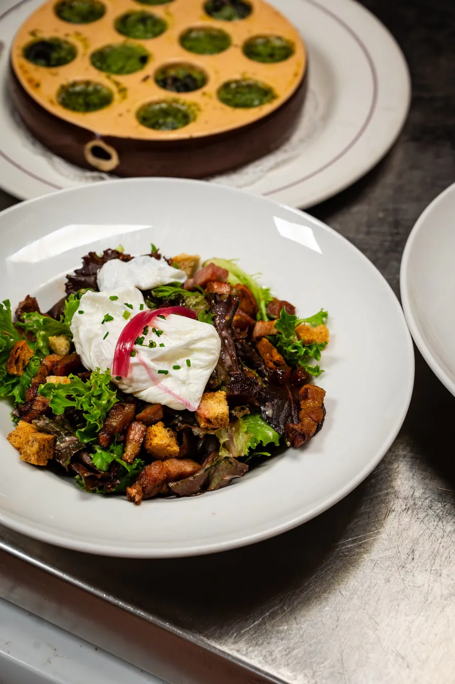 A Lyonnaise salad with poached egg and snails in parsley butter