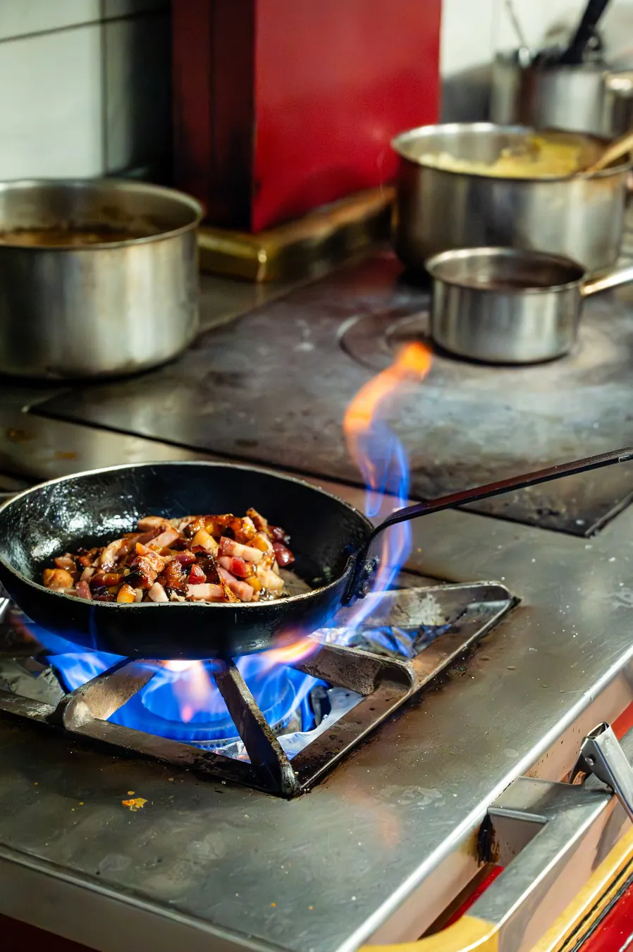 Lardons seared over a high flame in a black pan