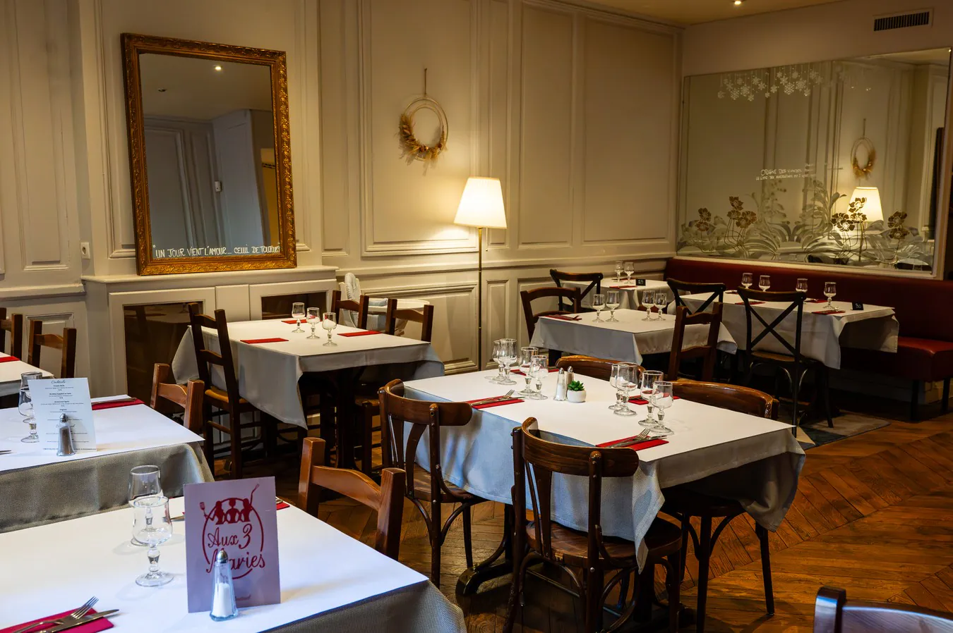 The upstairs room: mouldings, gilt mirror and laid tables