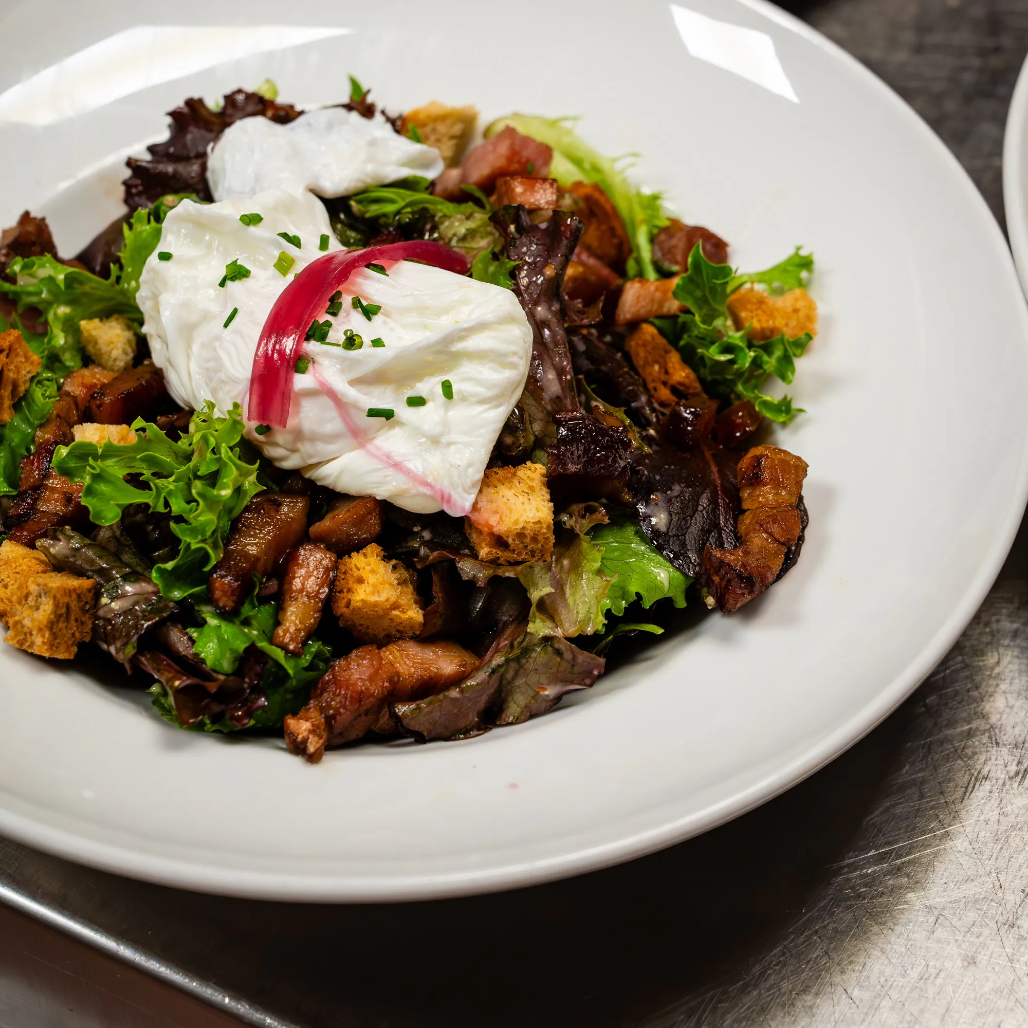 Traditional Lyonnaise salad: green salad, bacon, croutons and poached egg.