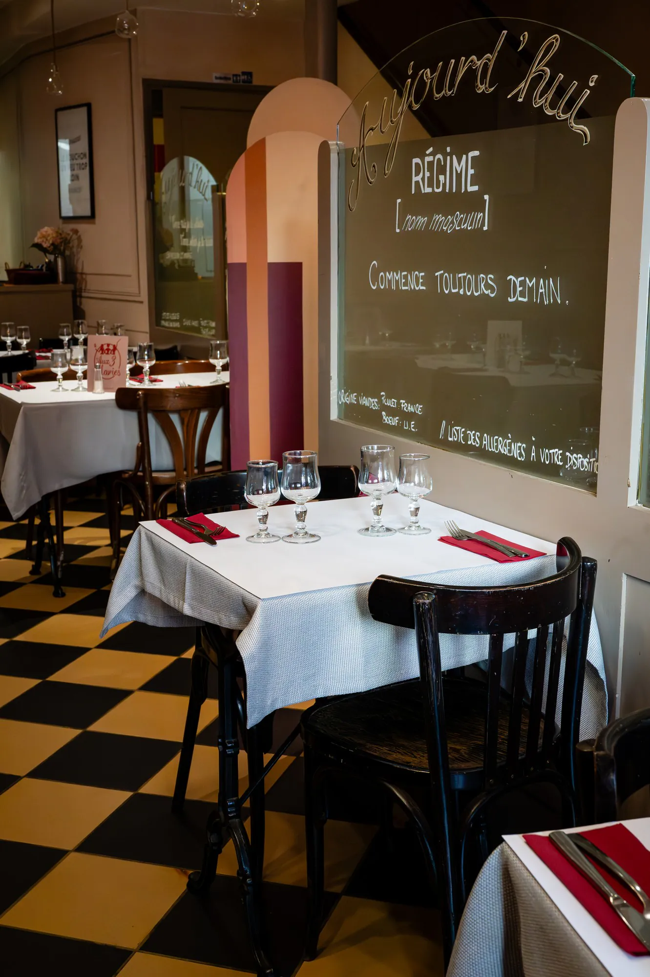Lyon bouchon dining room with a black-and-white chequered floor and white-linen tables