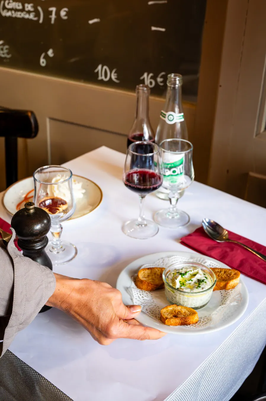 A hand setting down a plate of cervelle de canut