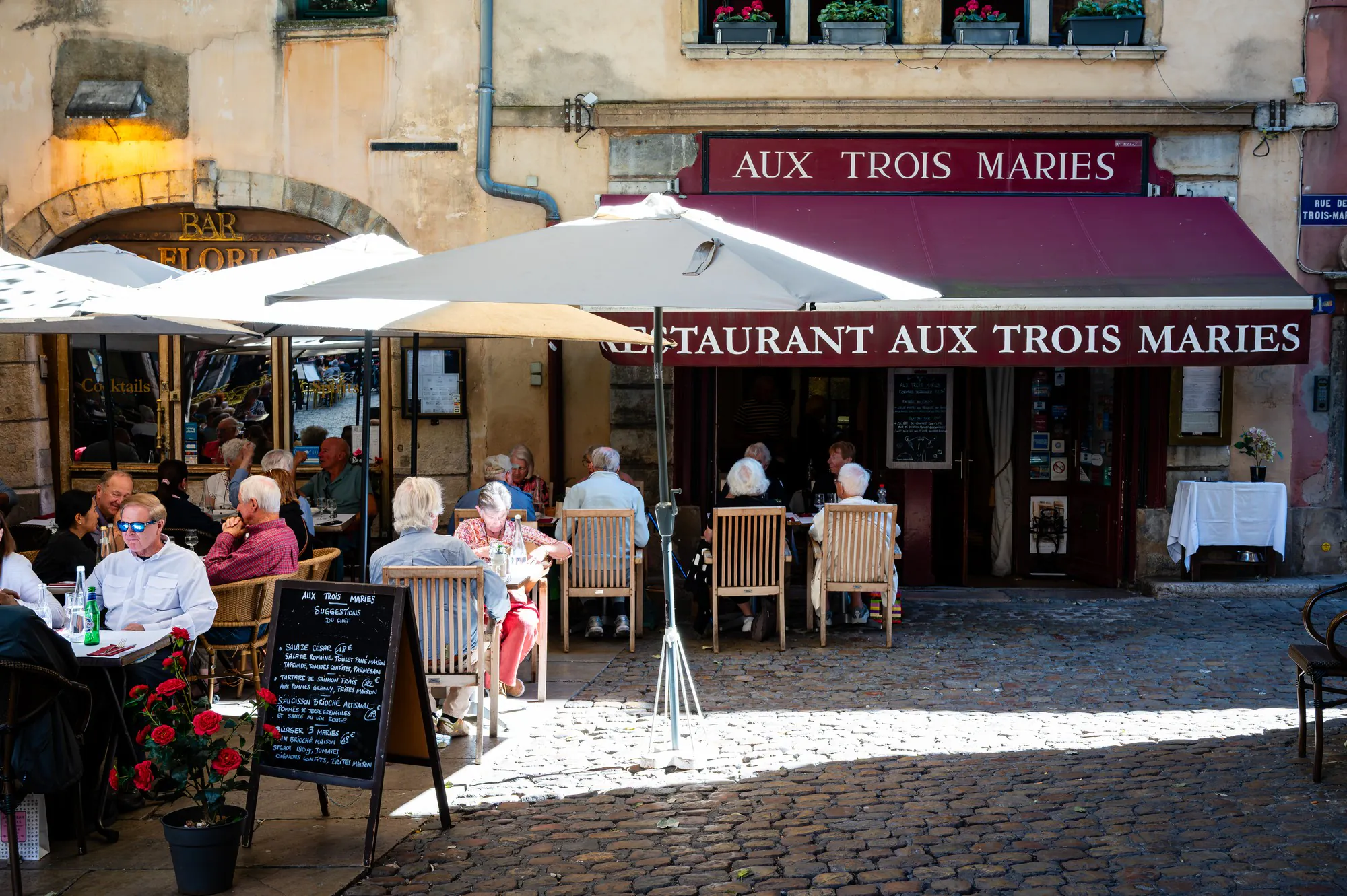 Terrasse animée d'un restaurant lyonnais dans une rue piétonne du Vieux-Lyon