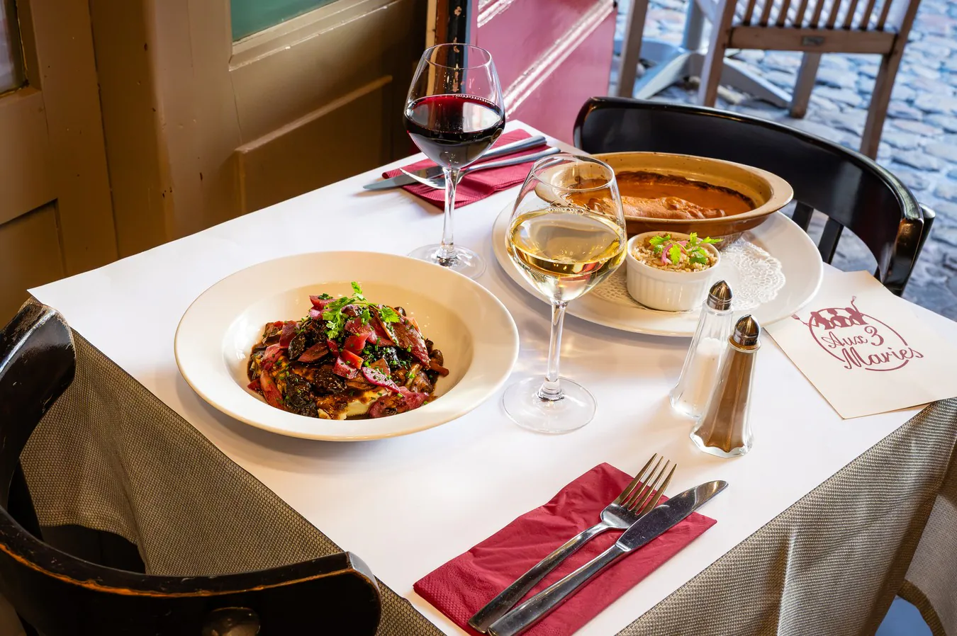 The stew of the moment served by the window, glasses of red and white