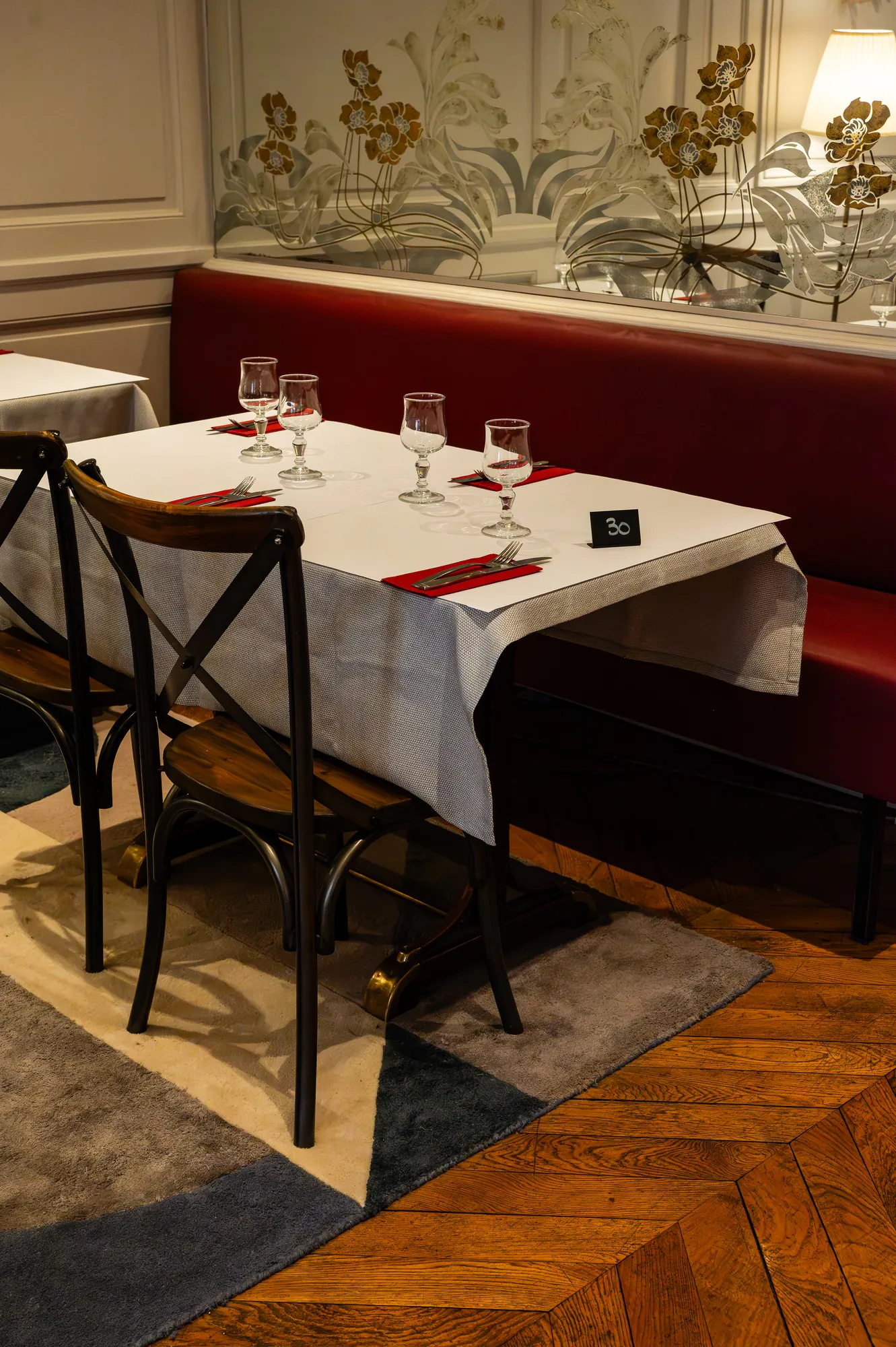 Table dressée d'un bouchon lyonnais : verres à pied, couverts et serviettes bordeaux
